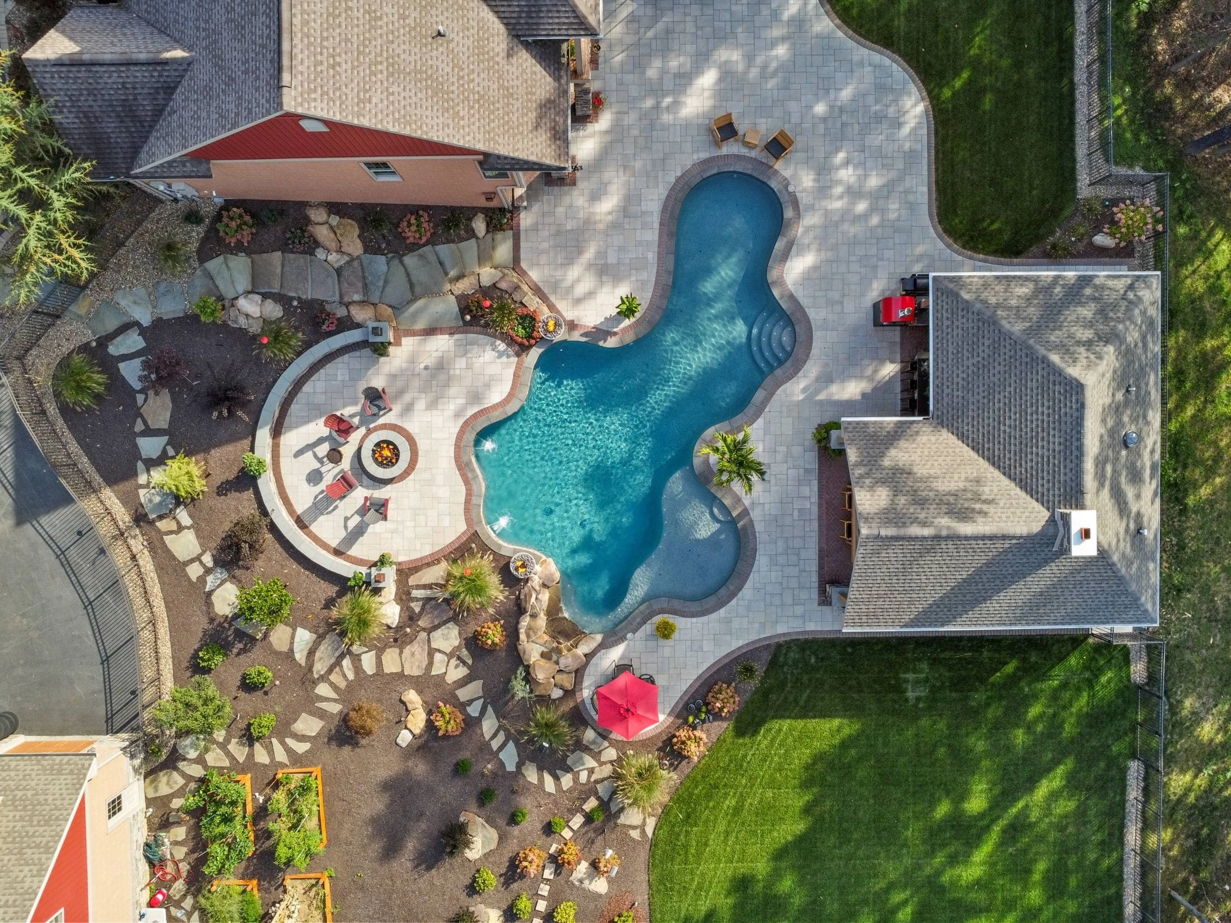 Curved fire pit patio surrounded by lush plantings in Dickinson Township, PA
