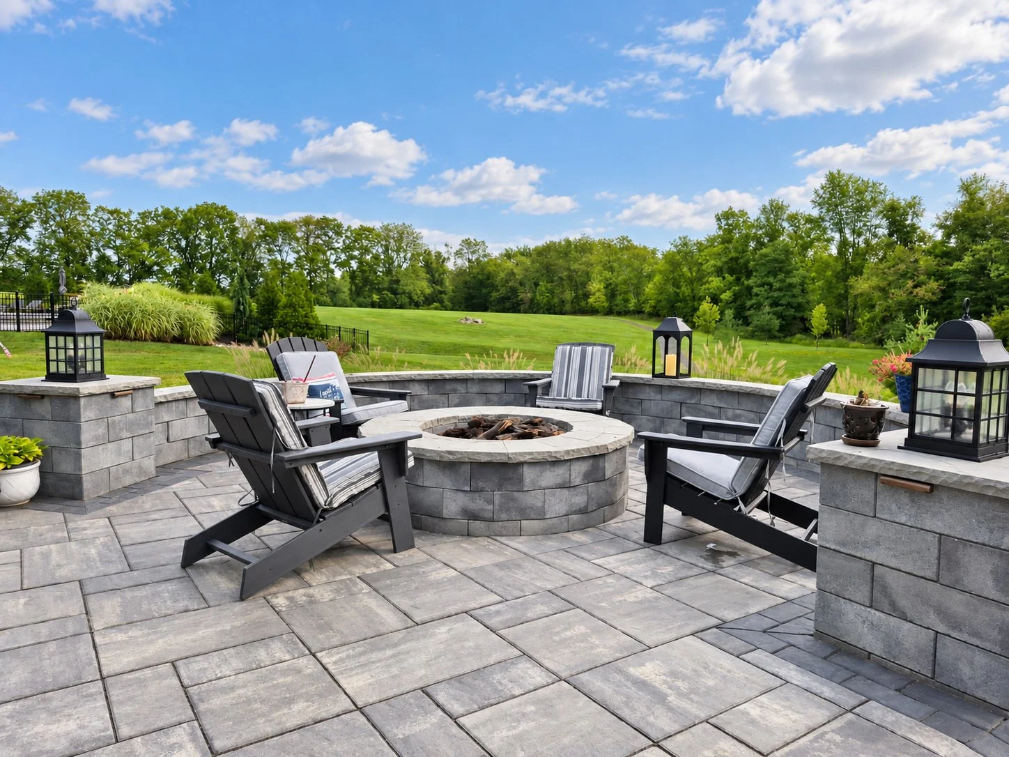 Large stone patio with outdoor fire pit and seating areas