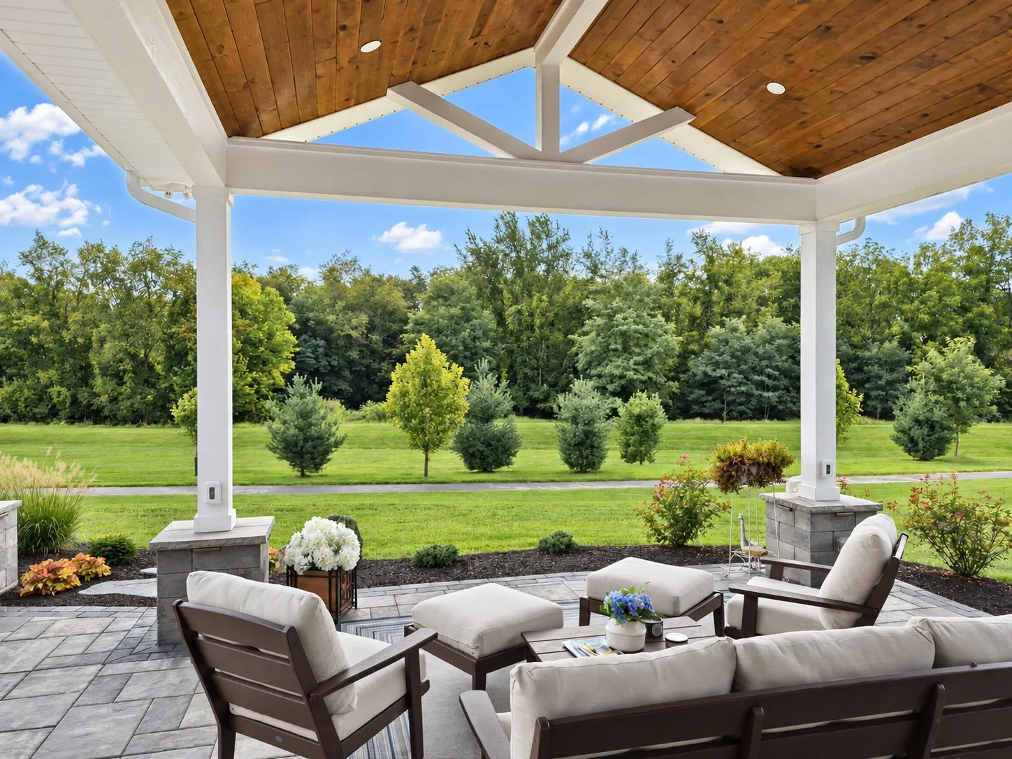 Covered outdoor pavilion with lounge seating and stone patio