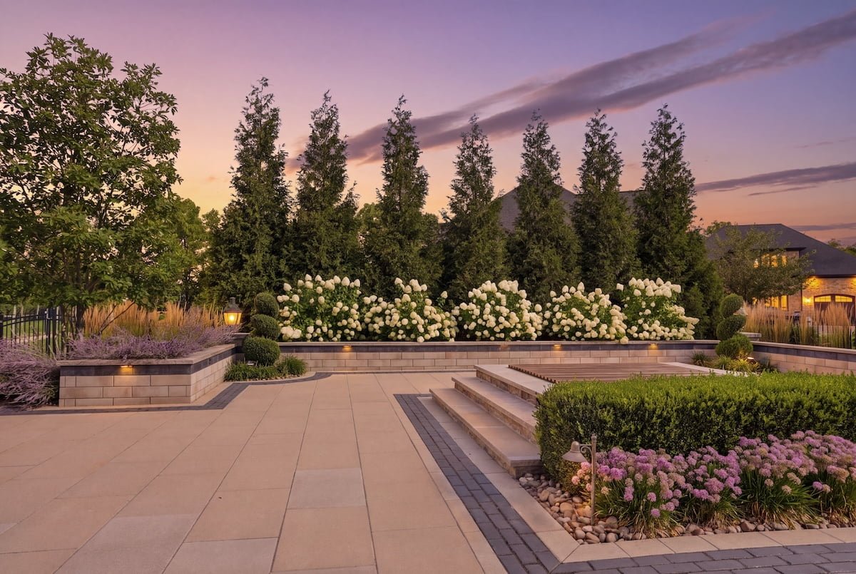 Symmetrical garden panel framed by clipped boxwood hedging and columnar evergreens — Weaver's Landscape Company