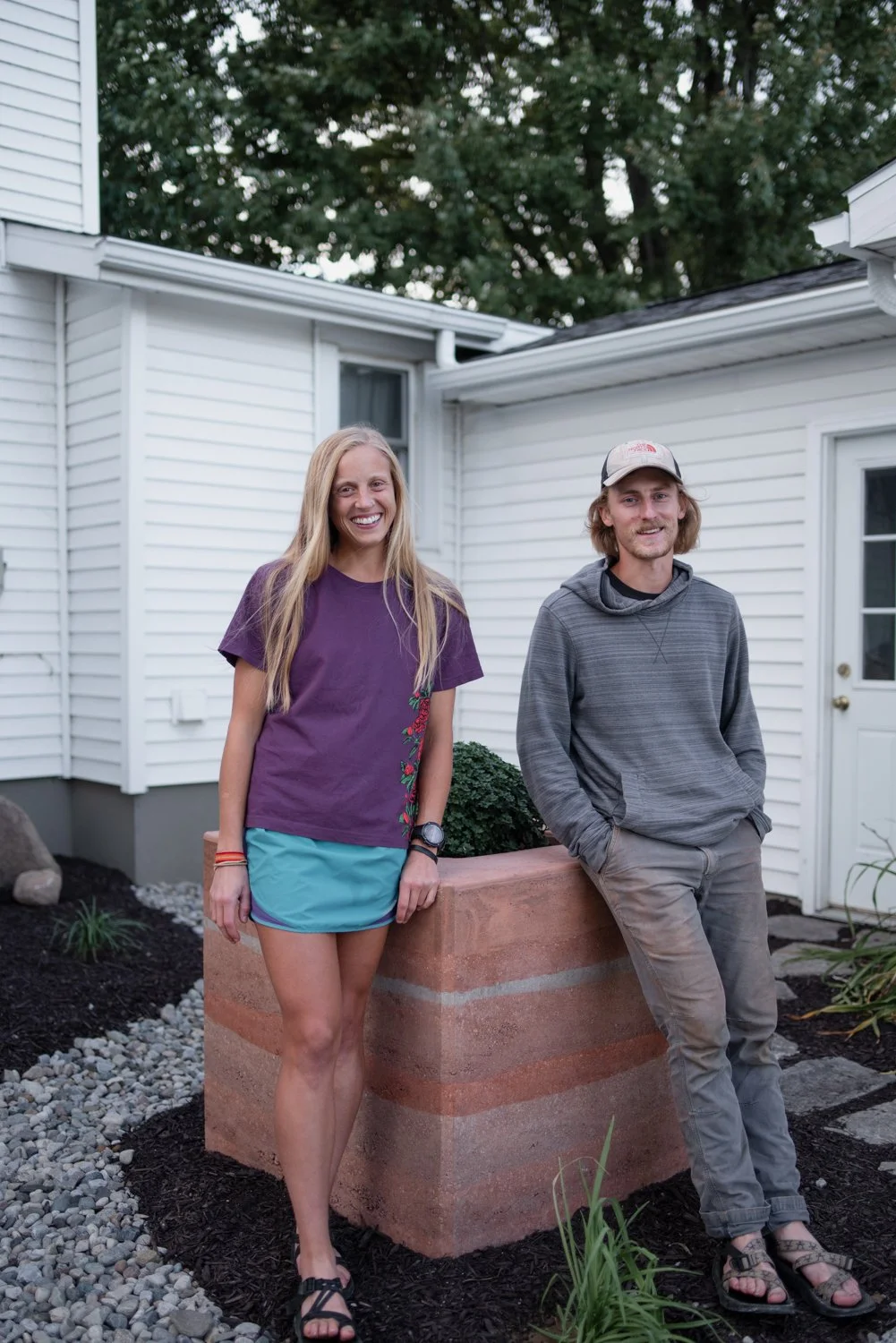 Caroline Wallace and Shay Myers standing beside the finished rammed earth planter box in Wauseon, Ohio designed and built by Solstice Design Studio 