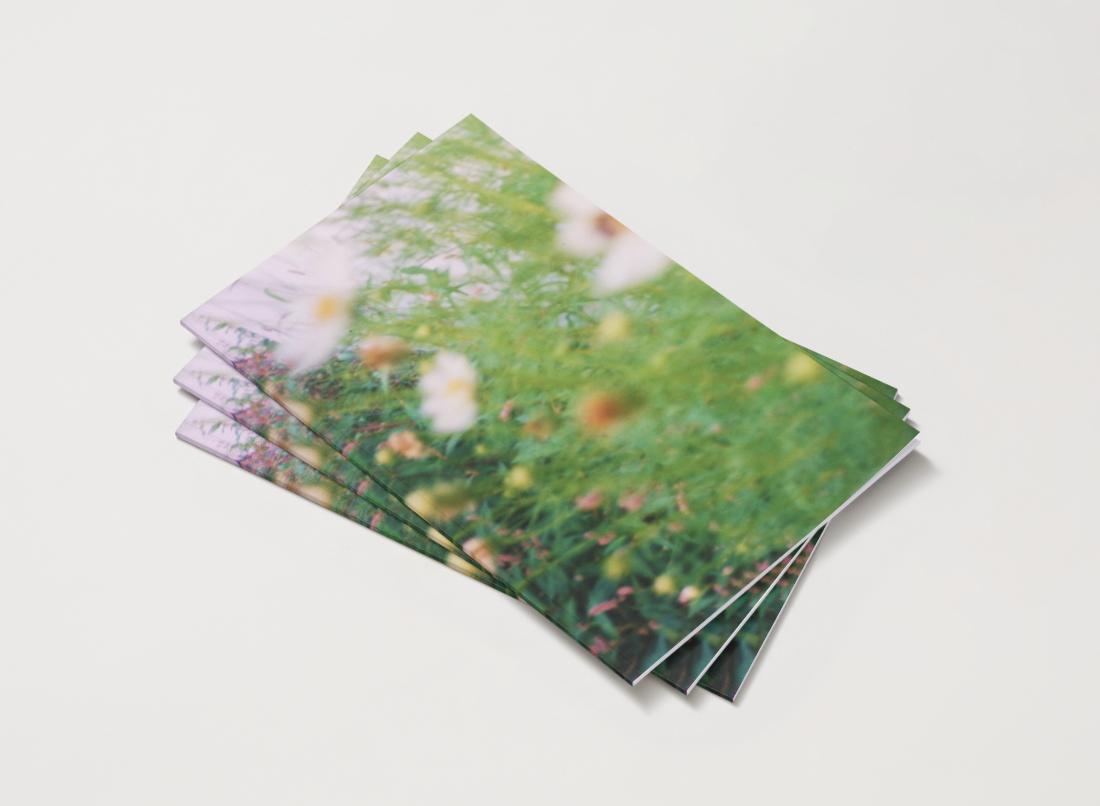 Stack of printed photographs featuring close-up images of flowers and green foliage.