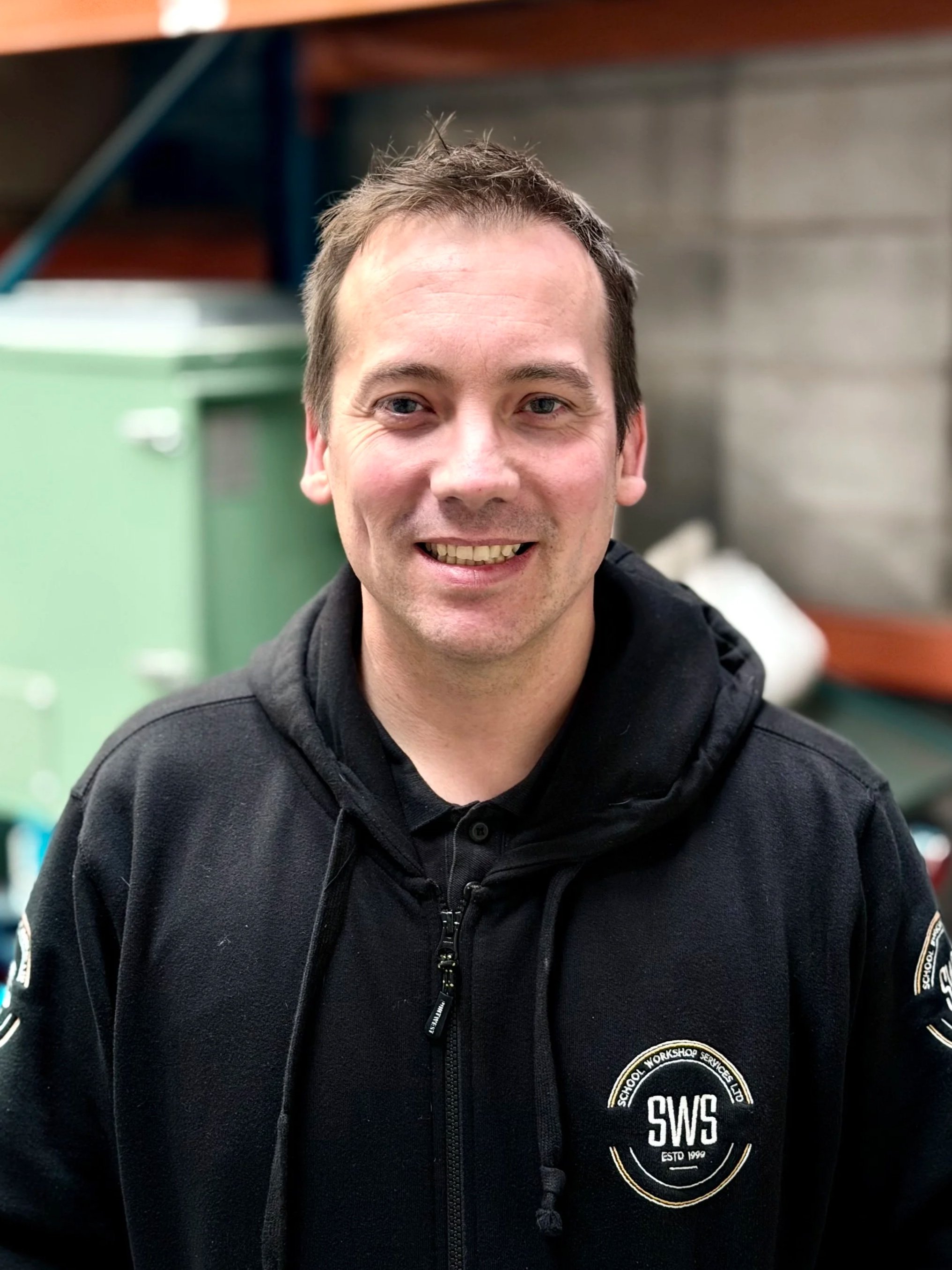 Photo of an engineer in work uniform smiling to the camera