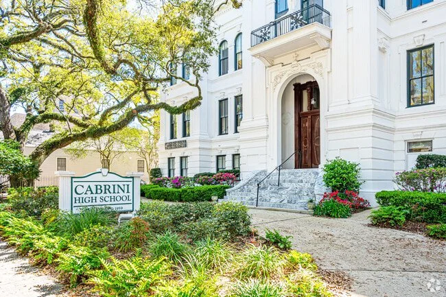 Exterior of Cabrini High School with a landscaped garden and a sign in the front yard.