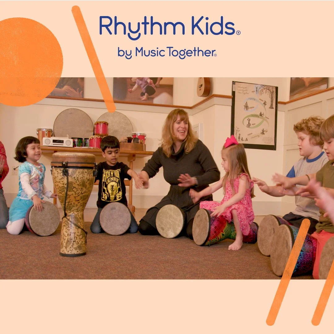 Group of young children and a teacher sitting on the floor in a circle, playing drums during a music class for Kids.