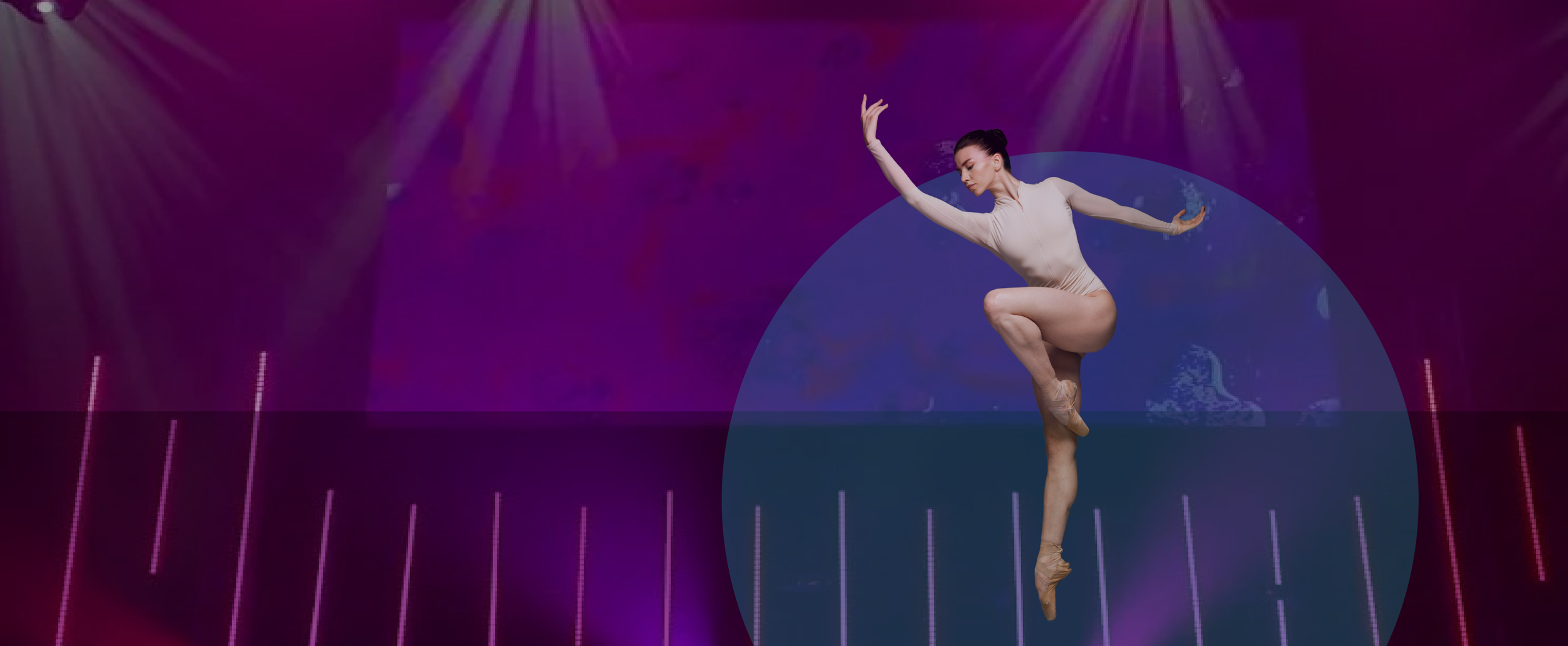 Two ballerinas performing on stage with colorful lights and a dark background