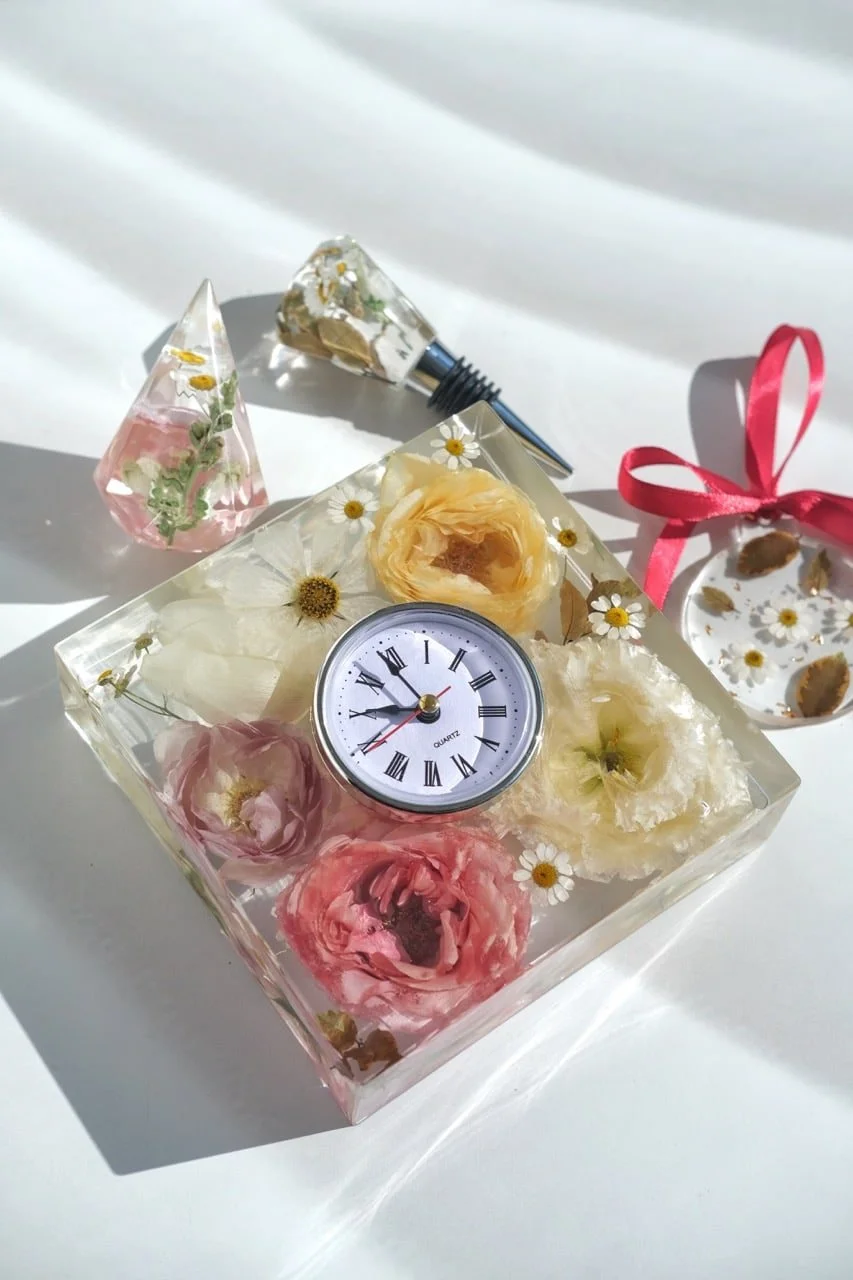A custom resin-preserved clock featuring elegant pink and orange wedding flowers.