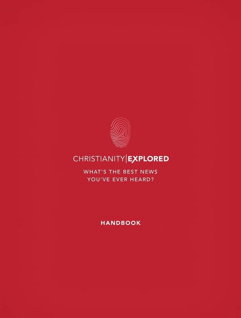 Red handbook titled "Christianity Explored" with a fingerprint icon and the subtitle "What's the best news you've ever heard?"