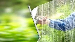 Person opening a window with a rain screen during a rainstorm
