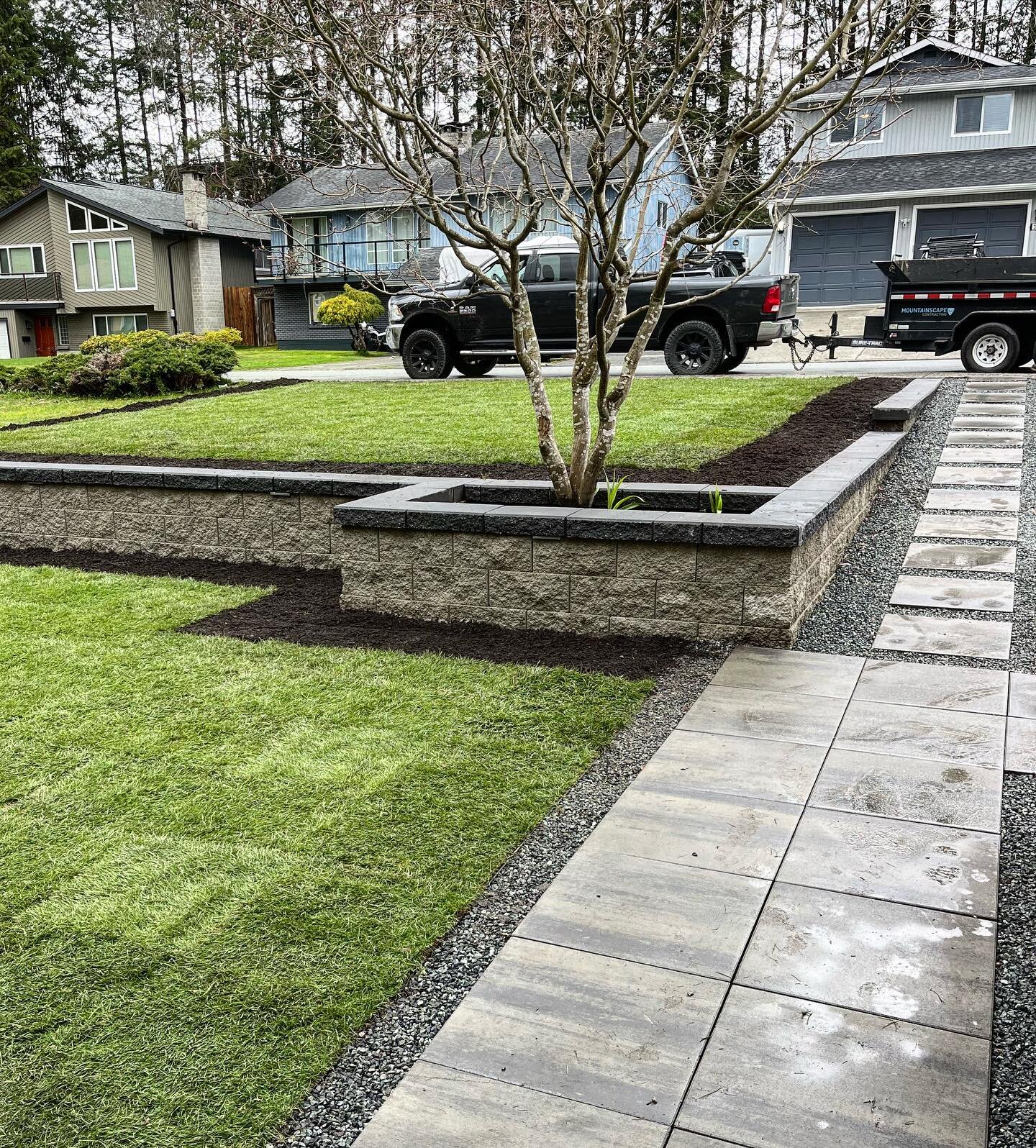 Clean and simple solution to a previously sloped yard. Tiered retaining wall and a low maintenance 2x2 path to the street. #mountainscape #basalite @basaliteconcreteproducts @belgardcanada #pavers #howtohardscape #hardscape #landscape #potd #igers #t