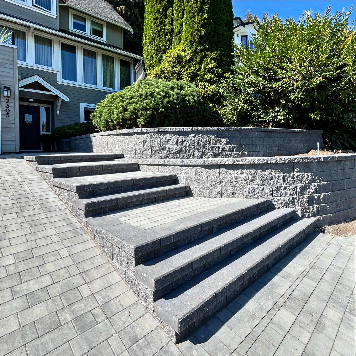 Newly installed! Curved valleystone staircase and tiered wall along a brand new 6x12 paving stone driveway. Project from demo to finish only took 2 weeks! @newstonegroup @basaliteconcreteproducts @creativebricksnblocks #mountainscape #hardscape #howt