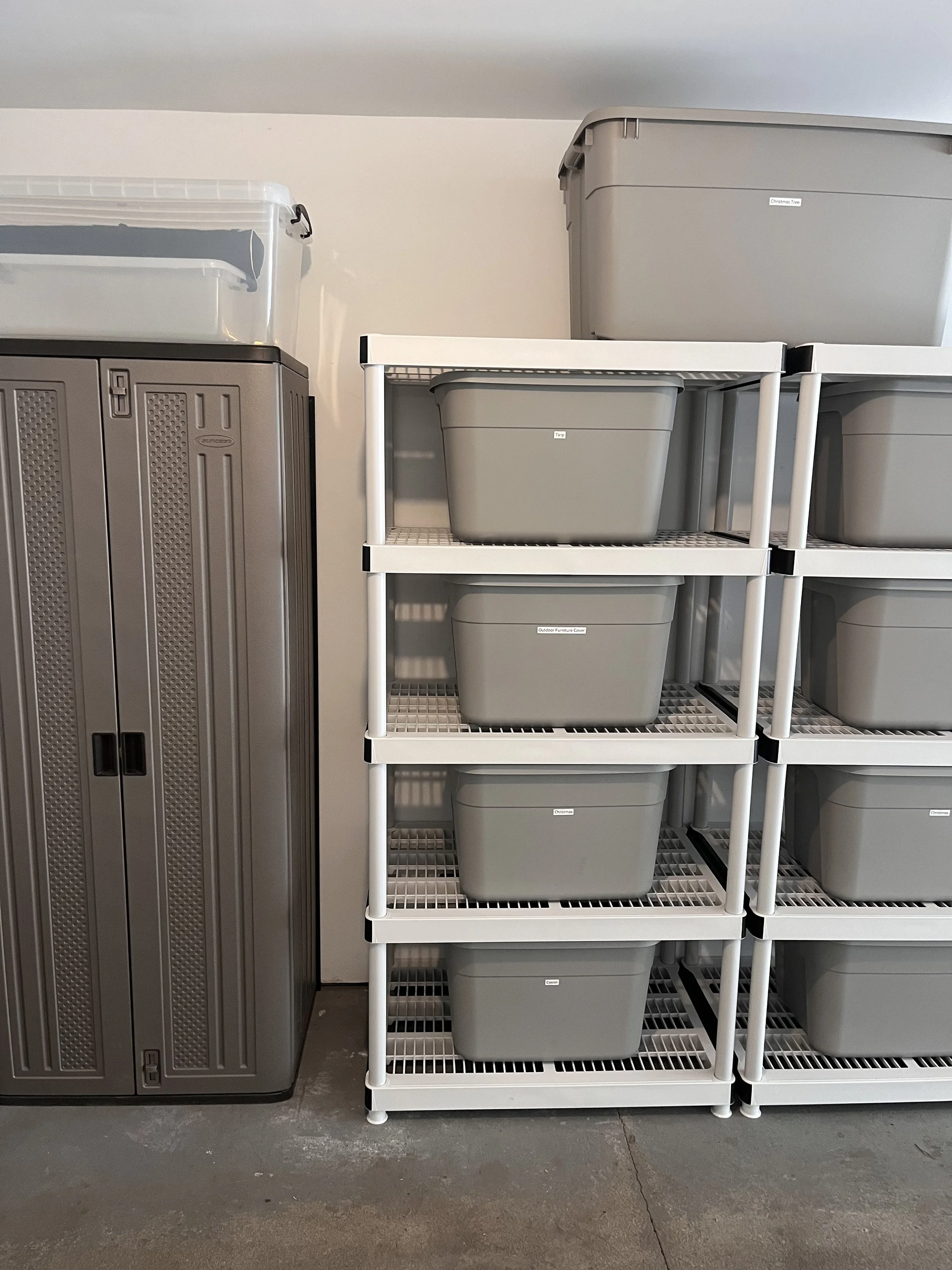 A storage room with a gray metal cabinet on the left and a white shelving unit with gray storage bins on the right.