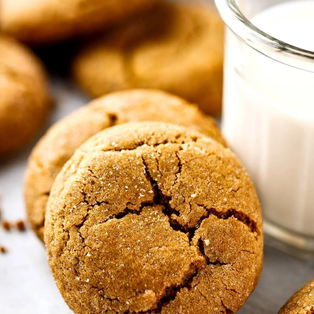 Soft ginger cookies next to a glass of milk.
