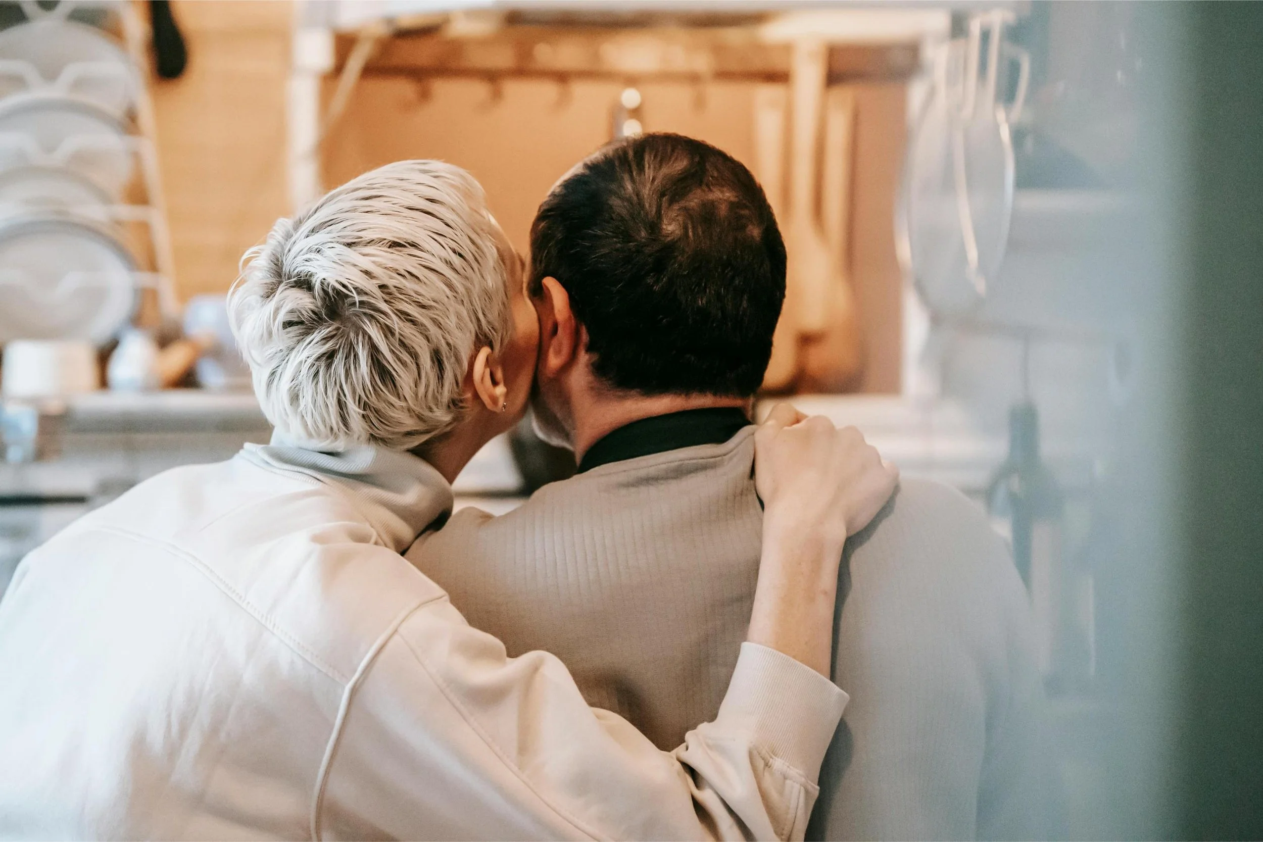 Couple sitting facing away from camera with cheeks touching