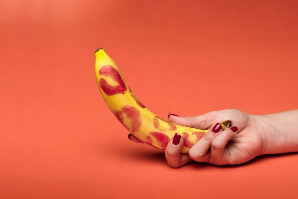 woman holding a banana with lipstick on it