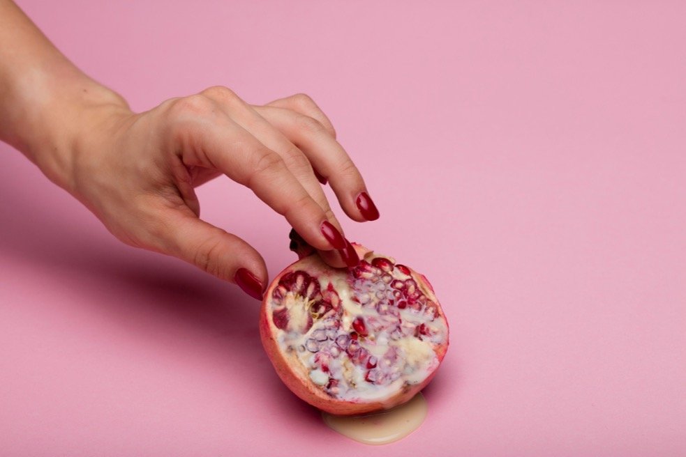 woman touching a pomegranate