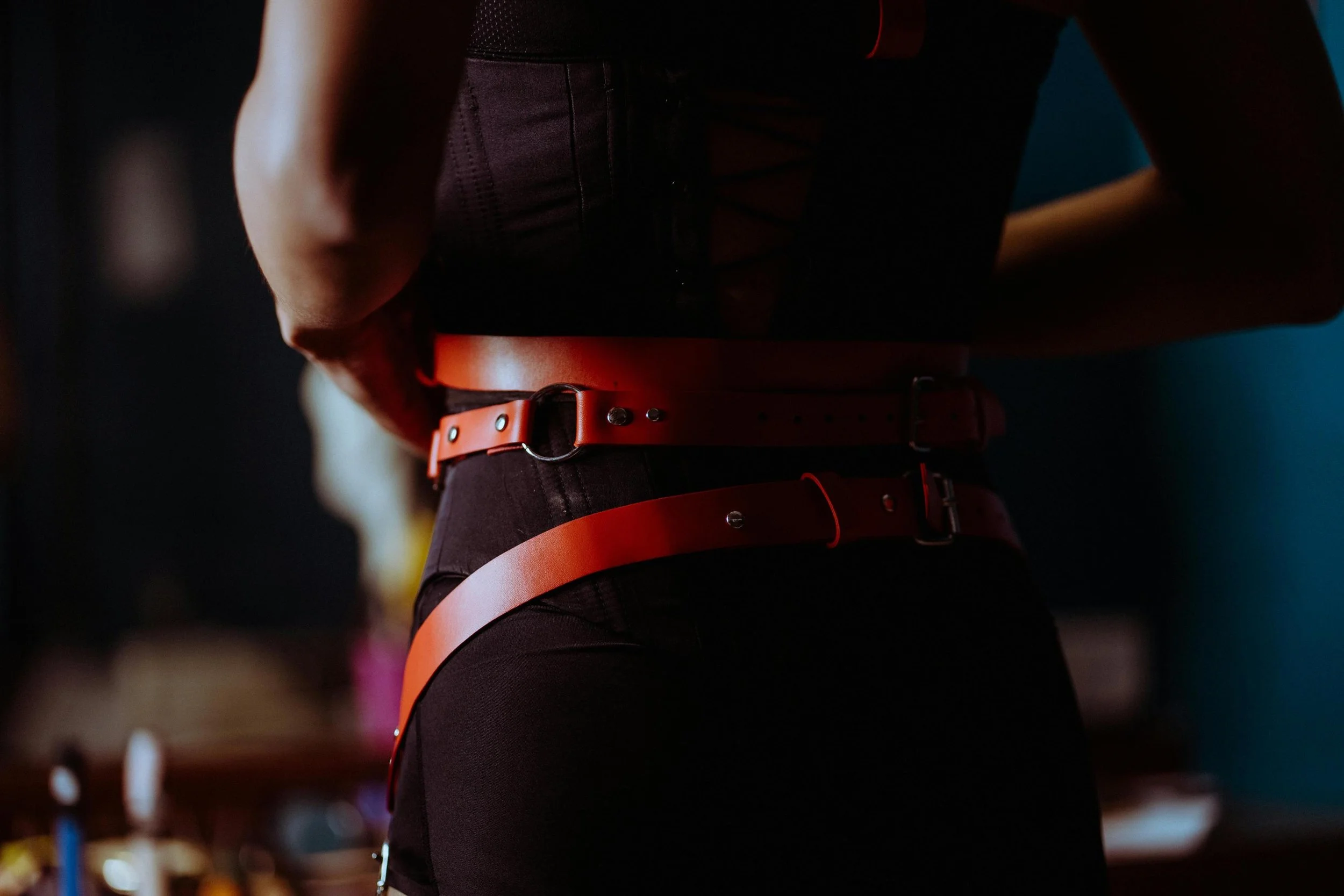 Female frame wearing an orange leather harness