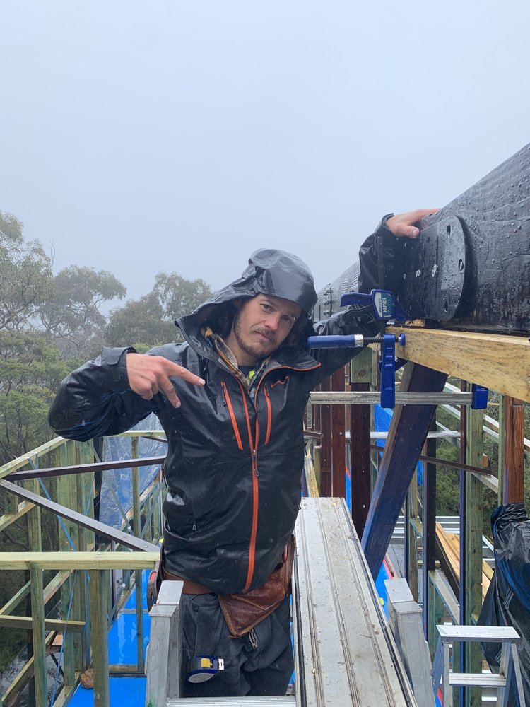  Josh Brown, unfazed by the rubbish weather and doing a cracking job installing our burnt site milled pine ridge beams and connection plates. 