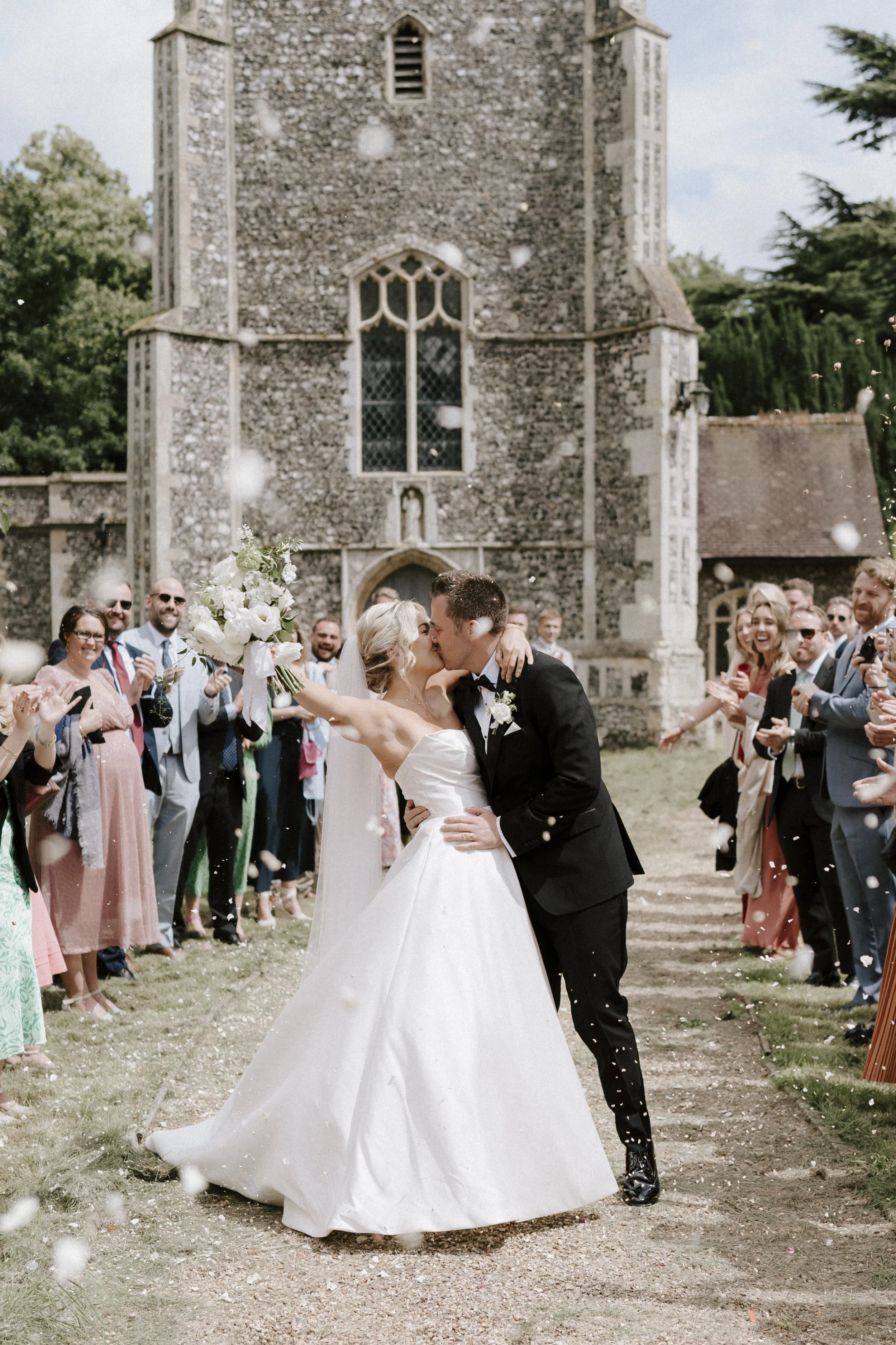 Bride and groom kissing outside church