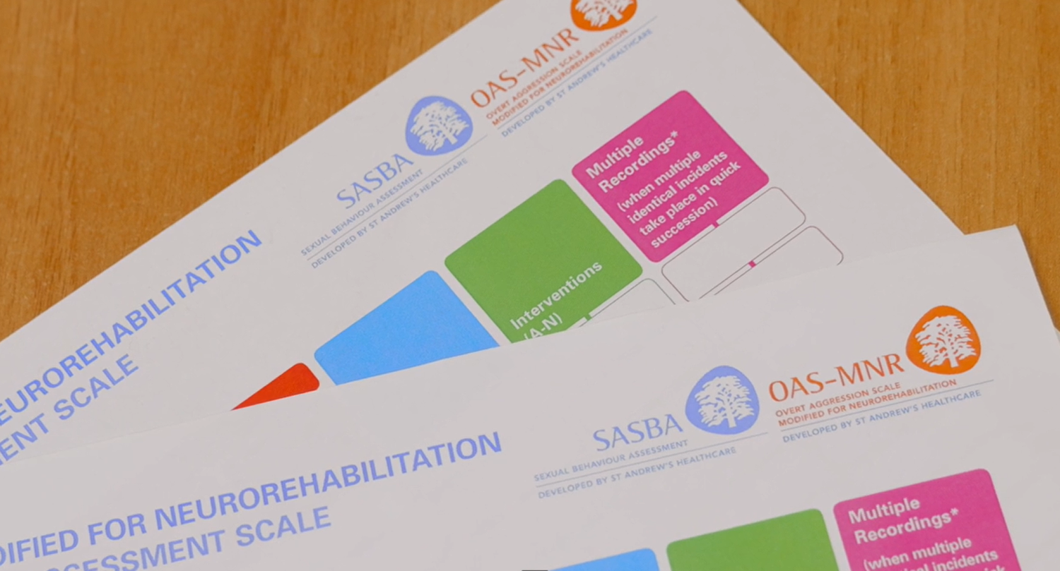 Paper OAS-MNR and SASBA assessment forms on a desk