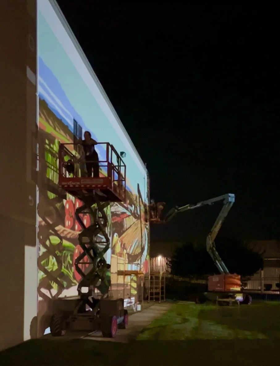 Image of two lifts and people working on a mural