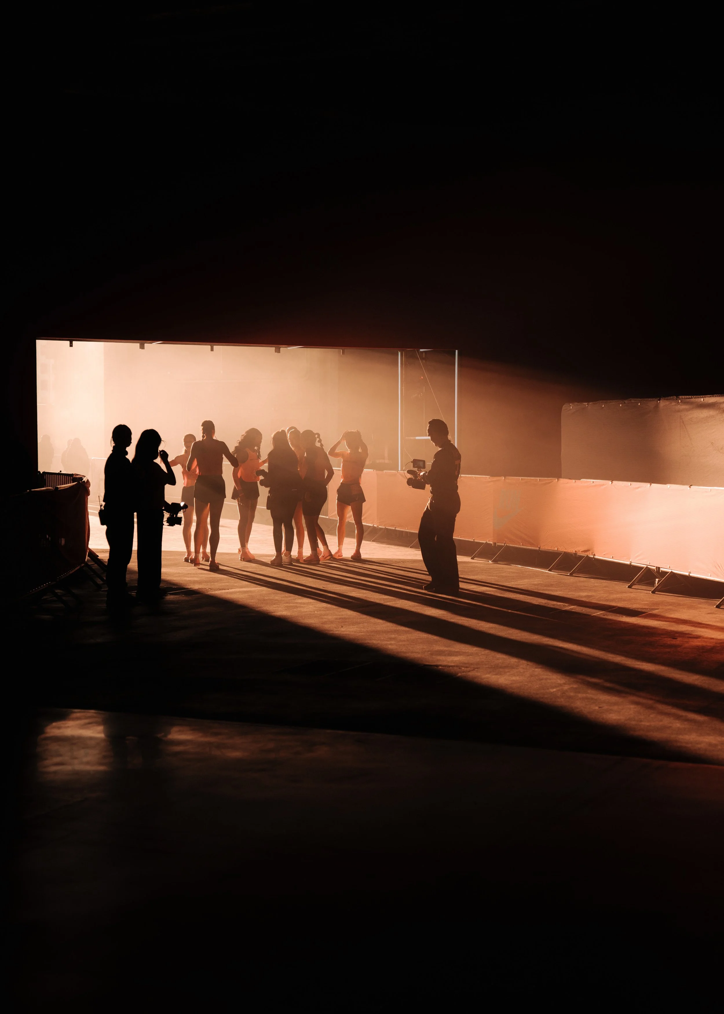 People gathered and photographed under bright lights at an indoor event or studio.