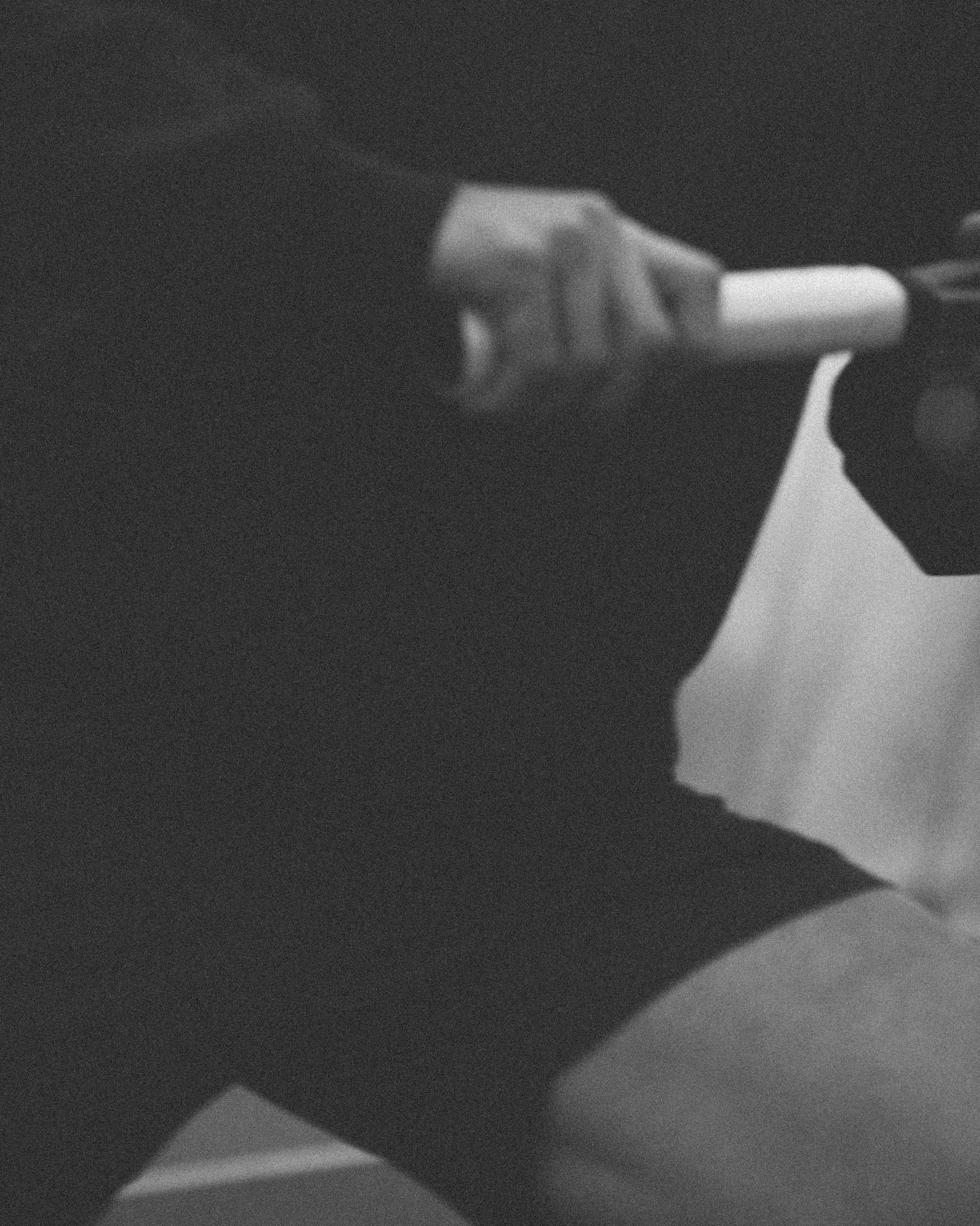 A person holding a marker and writing on a whiteboard or paper in a dark environment