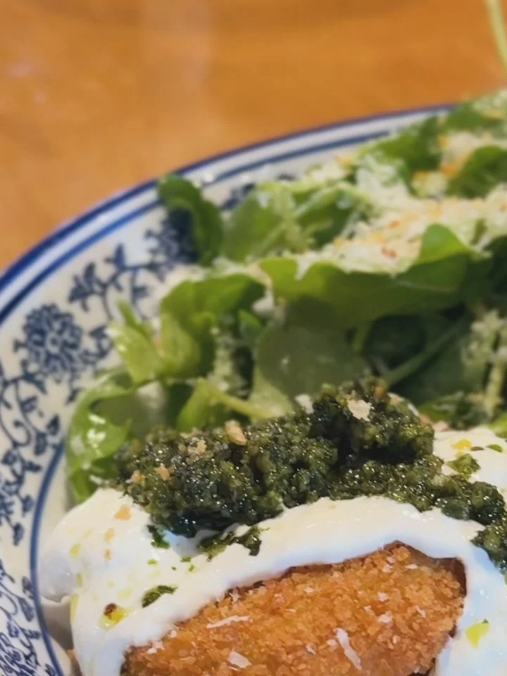 Fried Green Tomato Milanese 🍅
Crispy panko-breaded green tomatoes topped with:
🌿 Housemade pistachio pesto
🧀 Stracciatella (the creamy center of burrata)

Served with a simple, summery arugula salad&mdash;tossed in olive oil &amp; lemon juice, wit