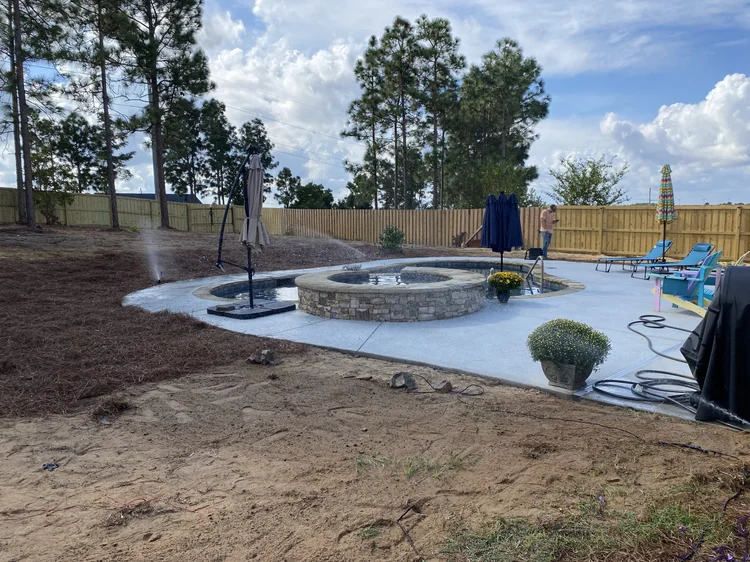 Sprinklers running around a new patio and fire pit