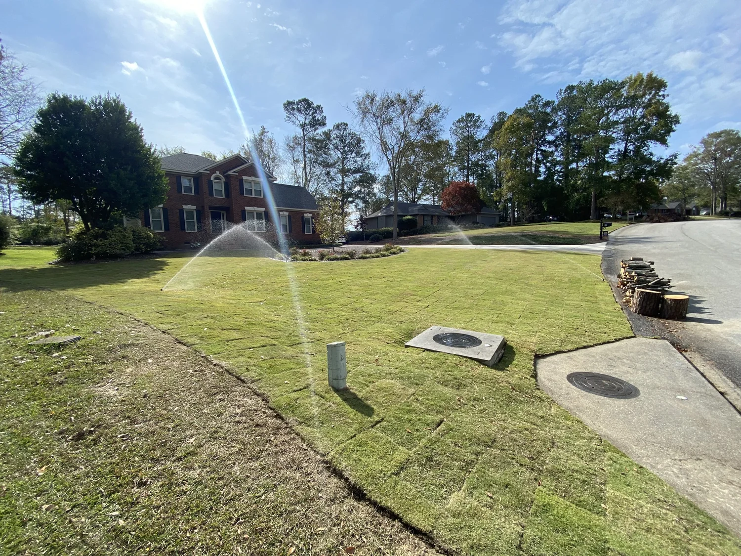 Sprinklers running on a healthy front lawn