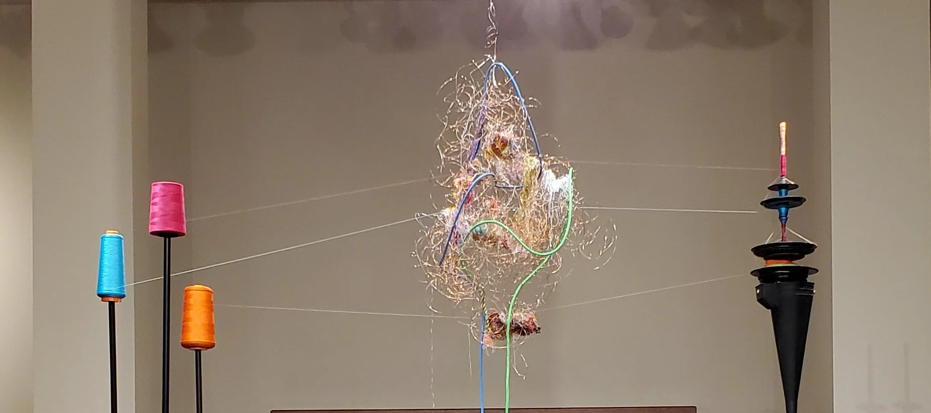 A close up of Neural KNot showing a wire sculpture with coulourful threads running through it.