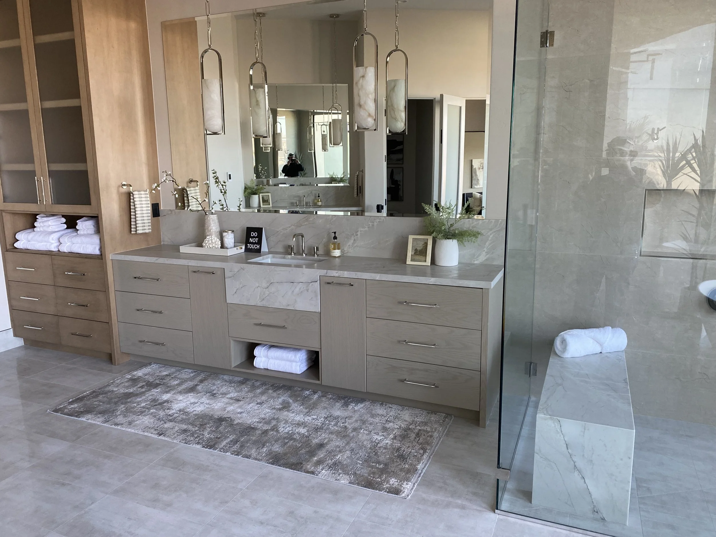 Primary bath & shower bench with quartzite countertops and miter apron