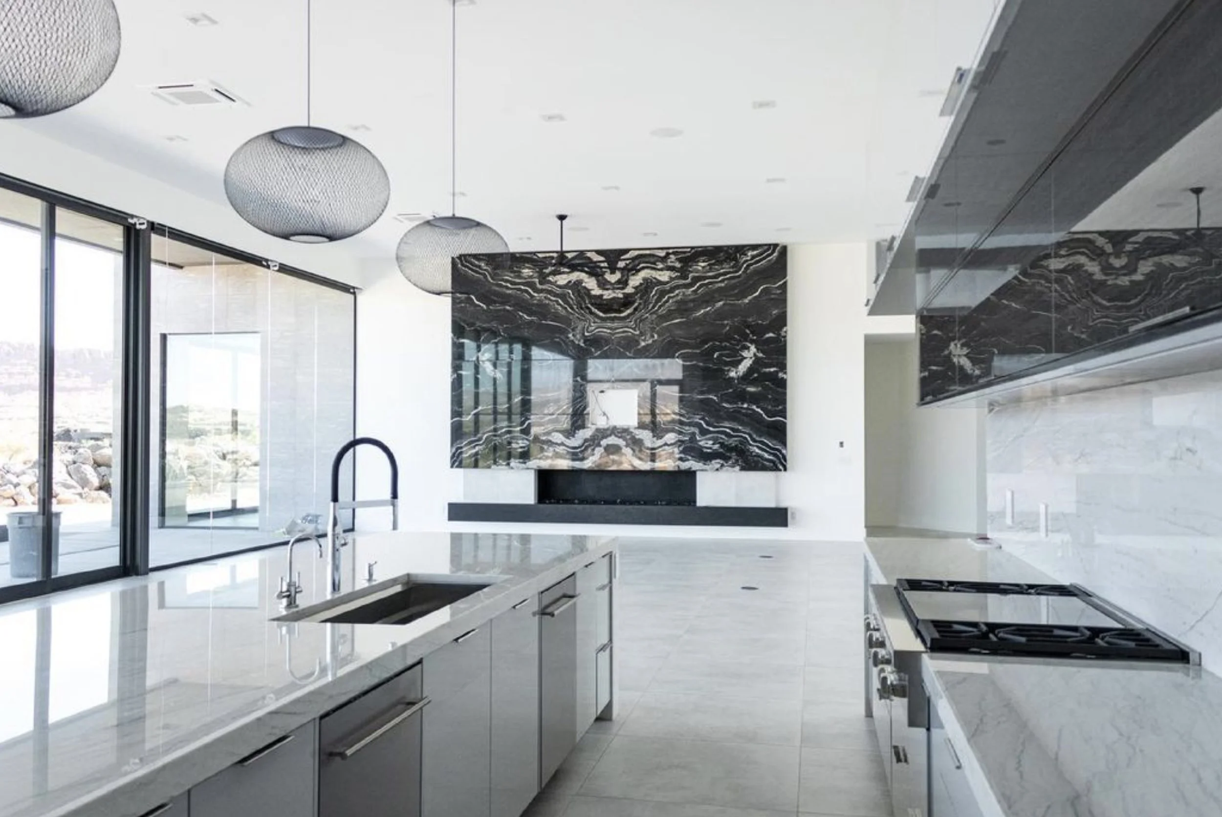 Kitchen & fireplace made out of quartzite with mitered edges and full height backsplash