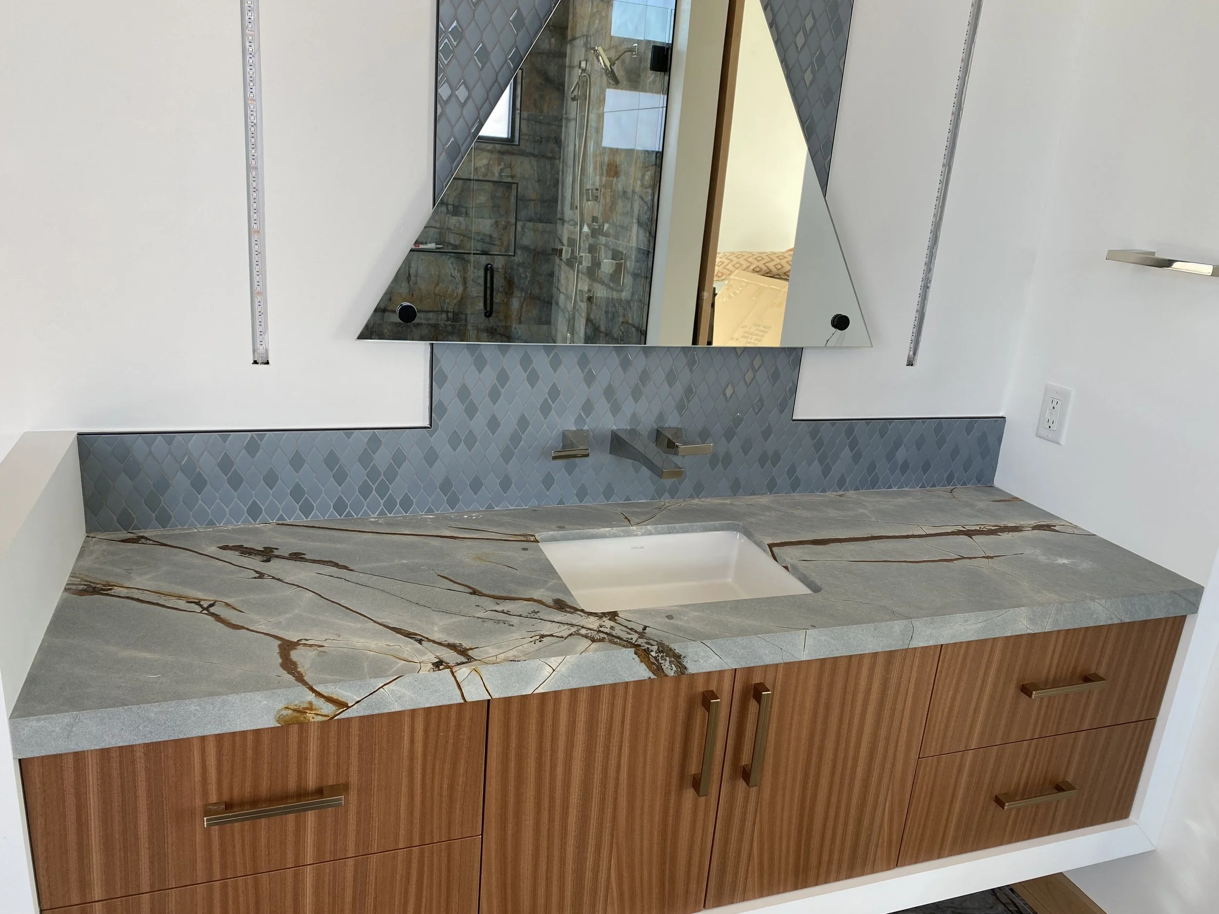 Primary bath with granite countertop and mitered edges