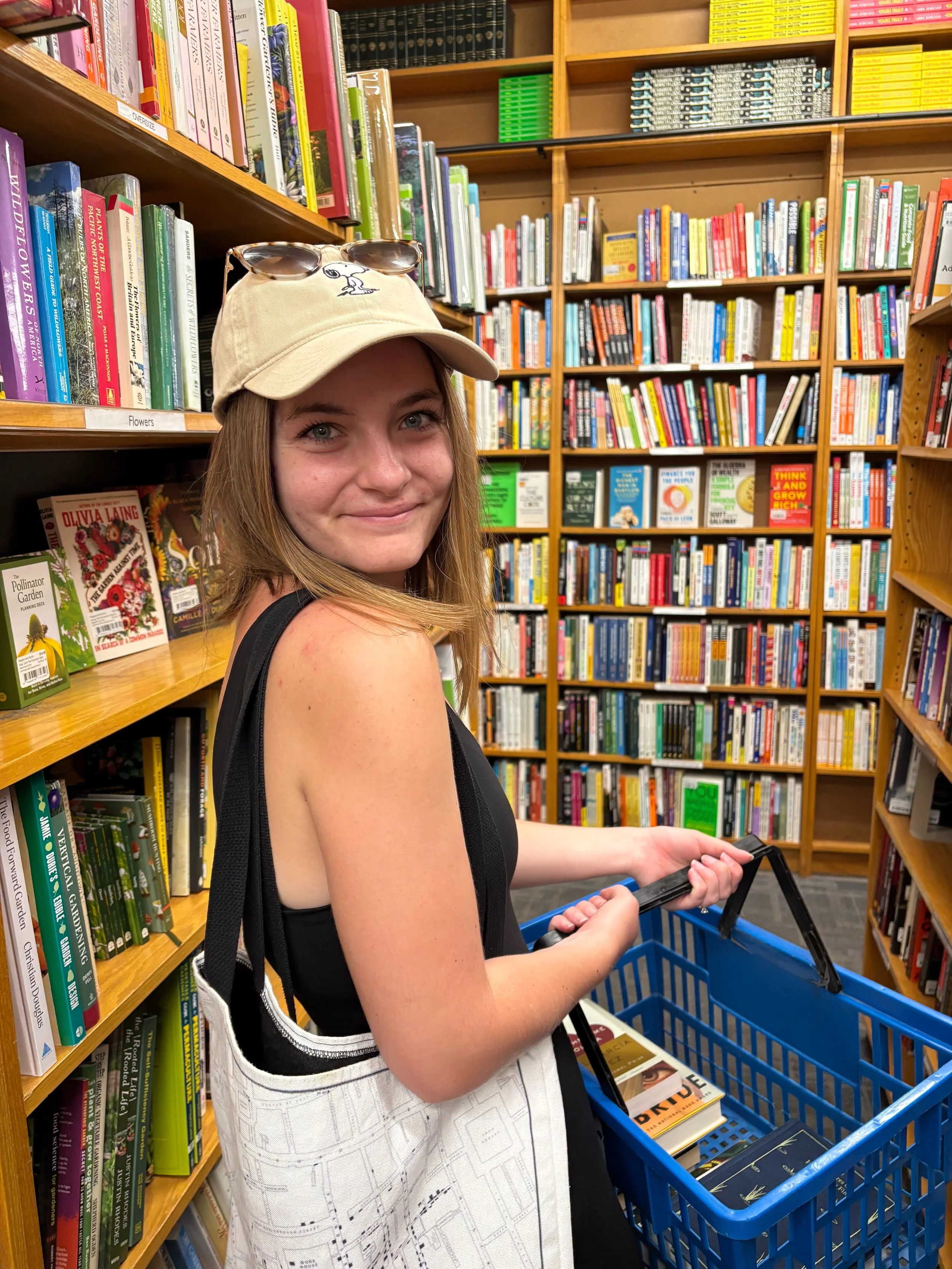 Young lady looking over her shoulder and smiling while looking for books in the library