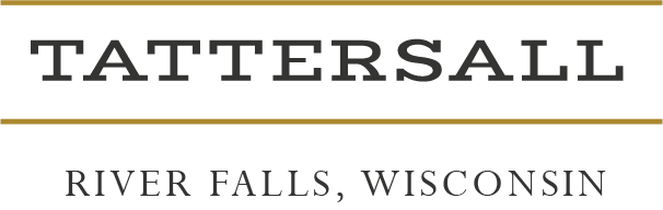 Close-up of a sign with the word 'TATTERSALL' and 'RIVER FALLS, WISCONSIN' written below it.
