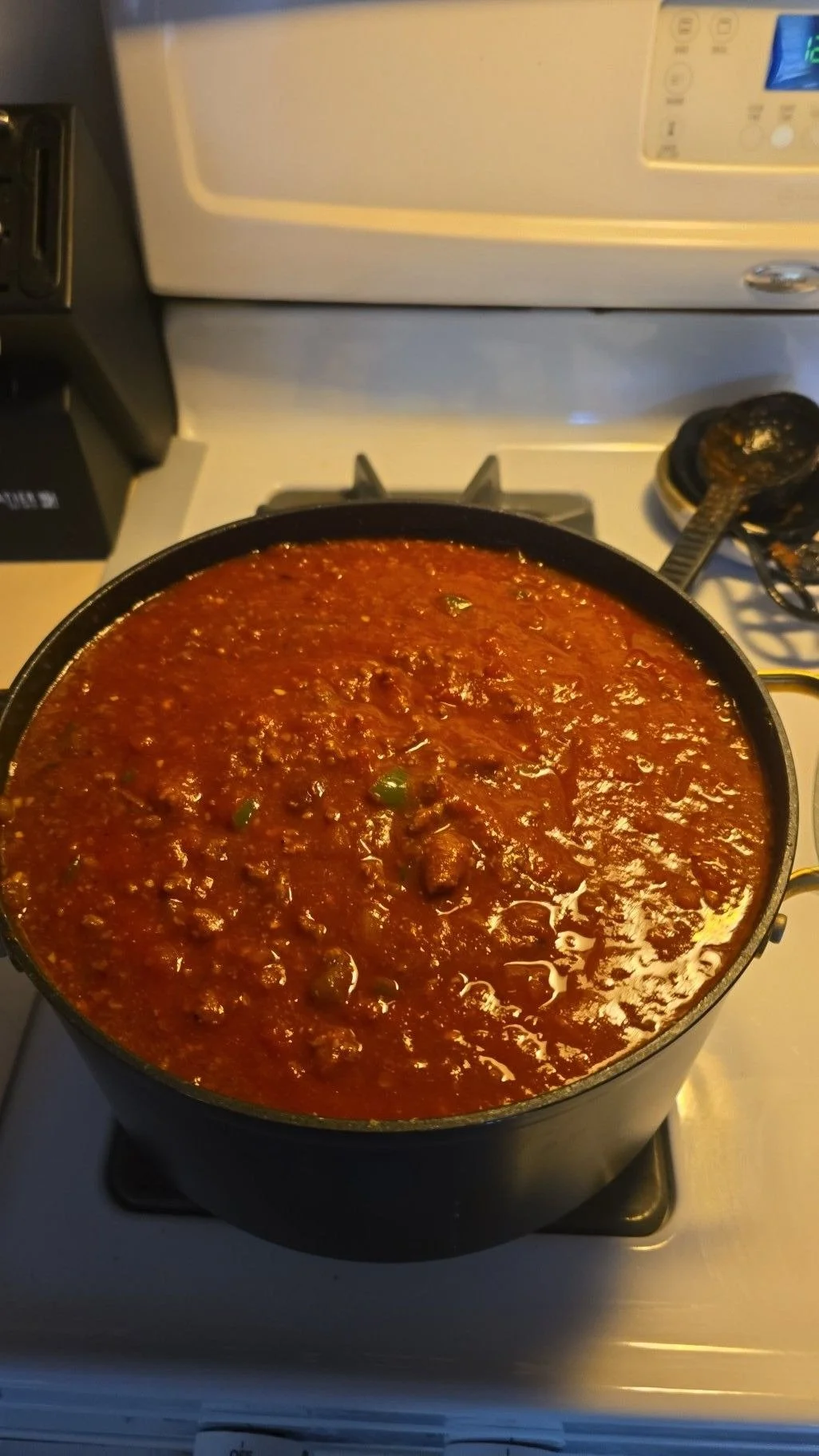 A full pot of chili sitting on a kitchen stove