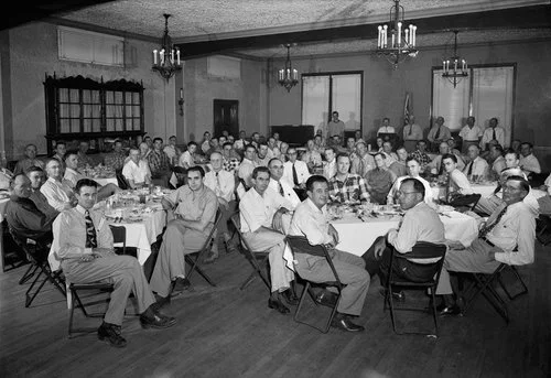 A large group of businessmen meet at Holland Hotel for an event in Alpine, Texas in this historical black and white photo.
