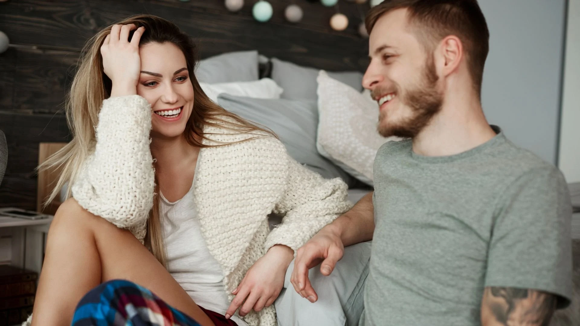 A couple engaging in an intimate and healthy conversation while sitting in a bedroom, illustrating effective relationship communication.