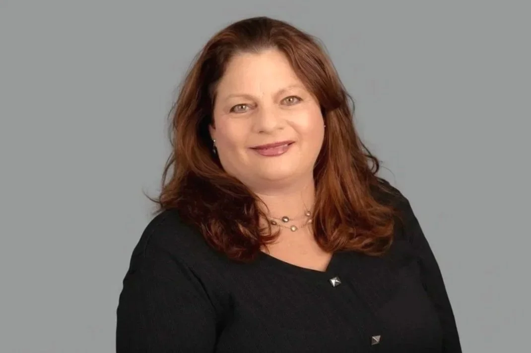 Professional headshot of Pam Golden, Senior Family Law Clerk at Drake Law, in formal attire, grey background behind her.