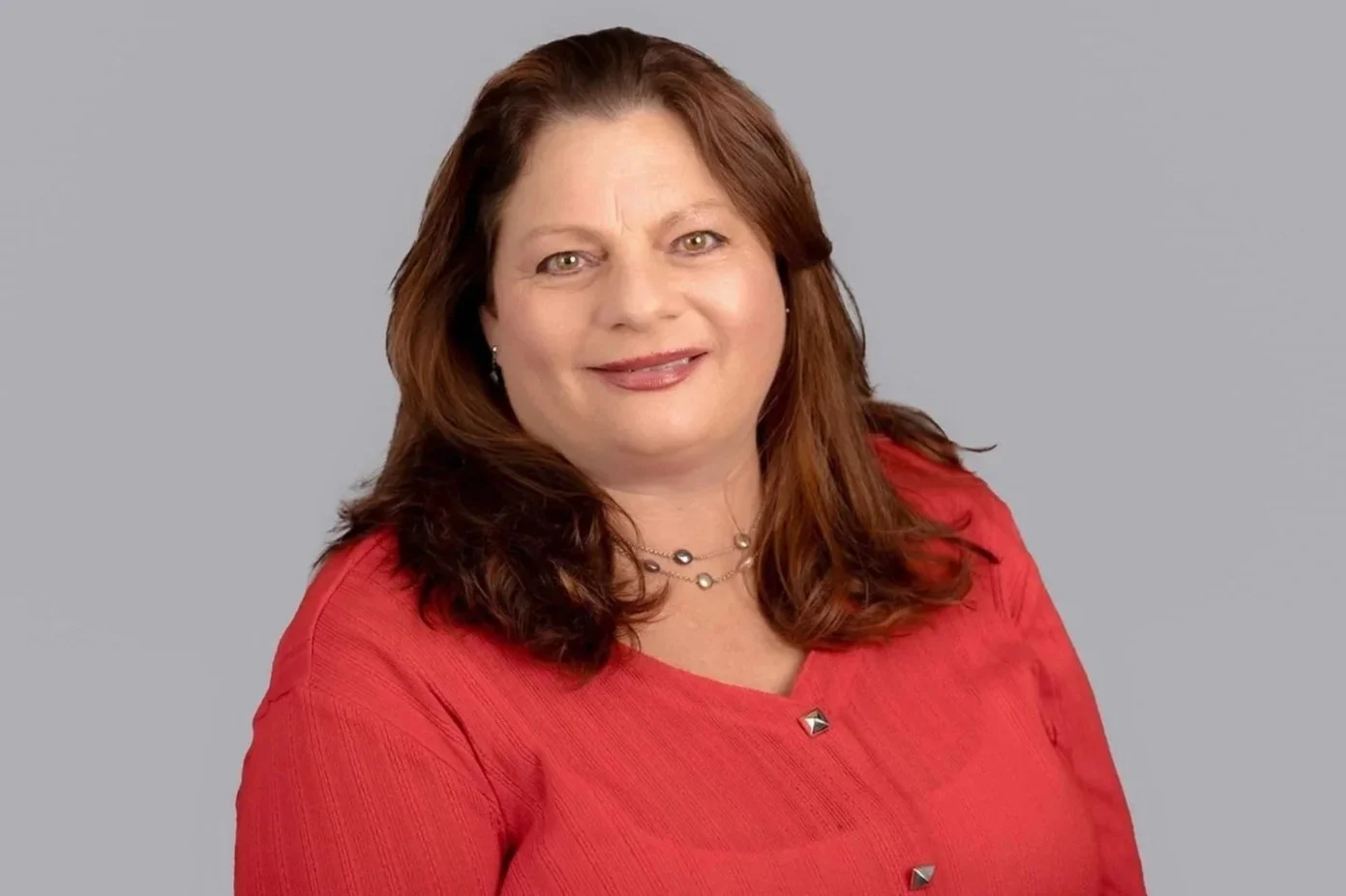 Professional headshot of Pam Golden, Senior Family Law Clerk at Drake Law, in formal attire, grey background behind her.