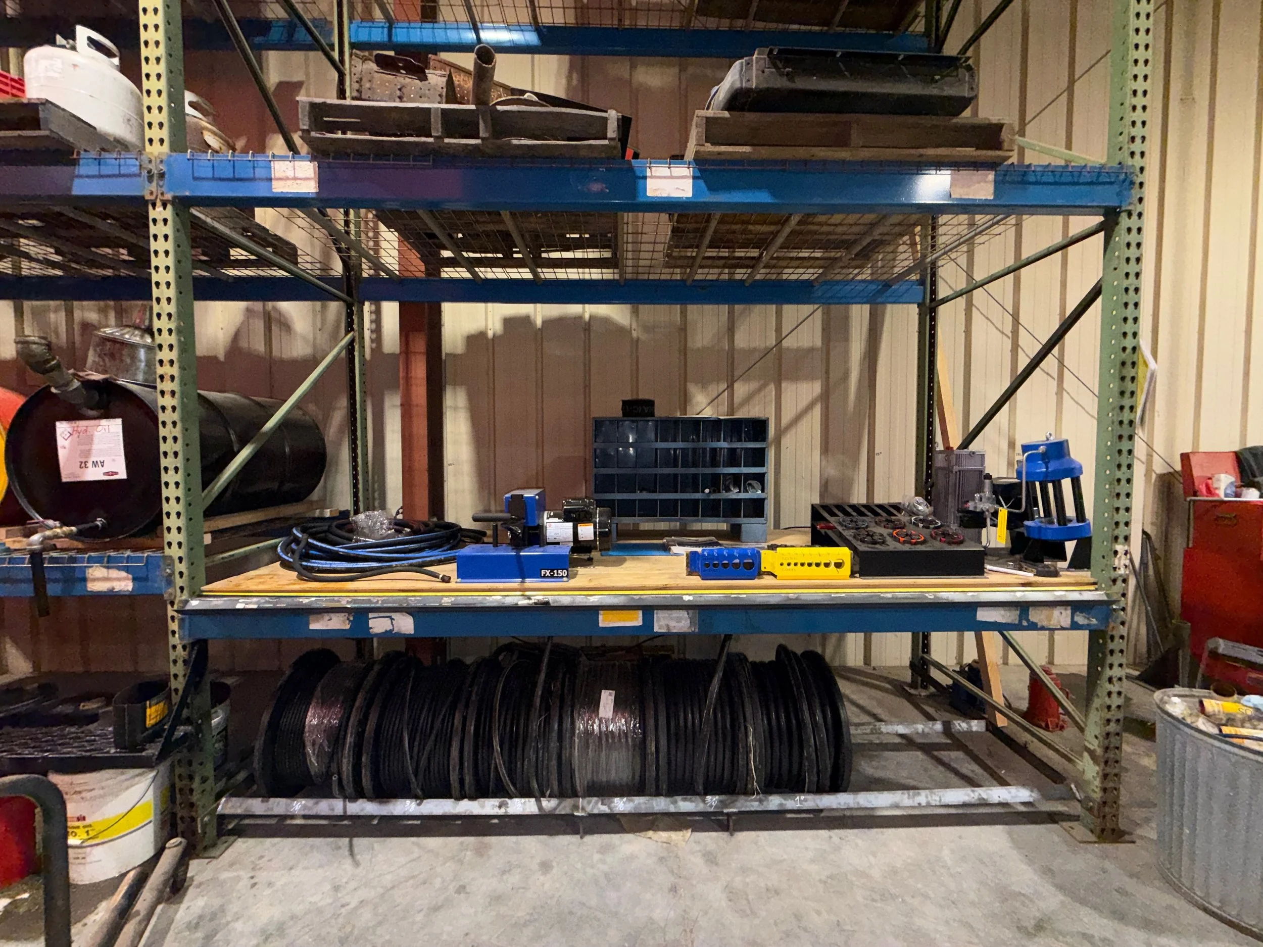 A metal shelving unit in a workshop, custom hydraulic fitting station, chest west virginia hydraulic repair shop and store front.