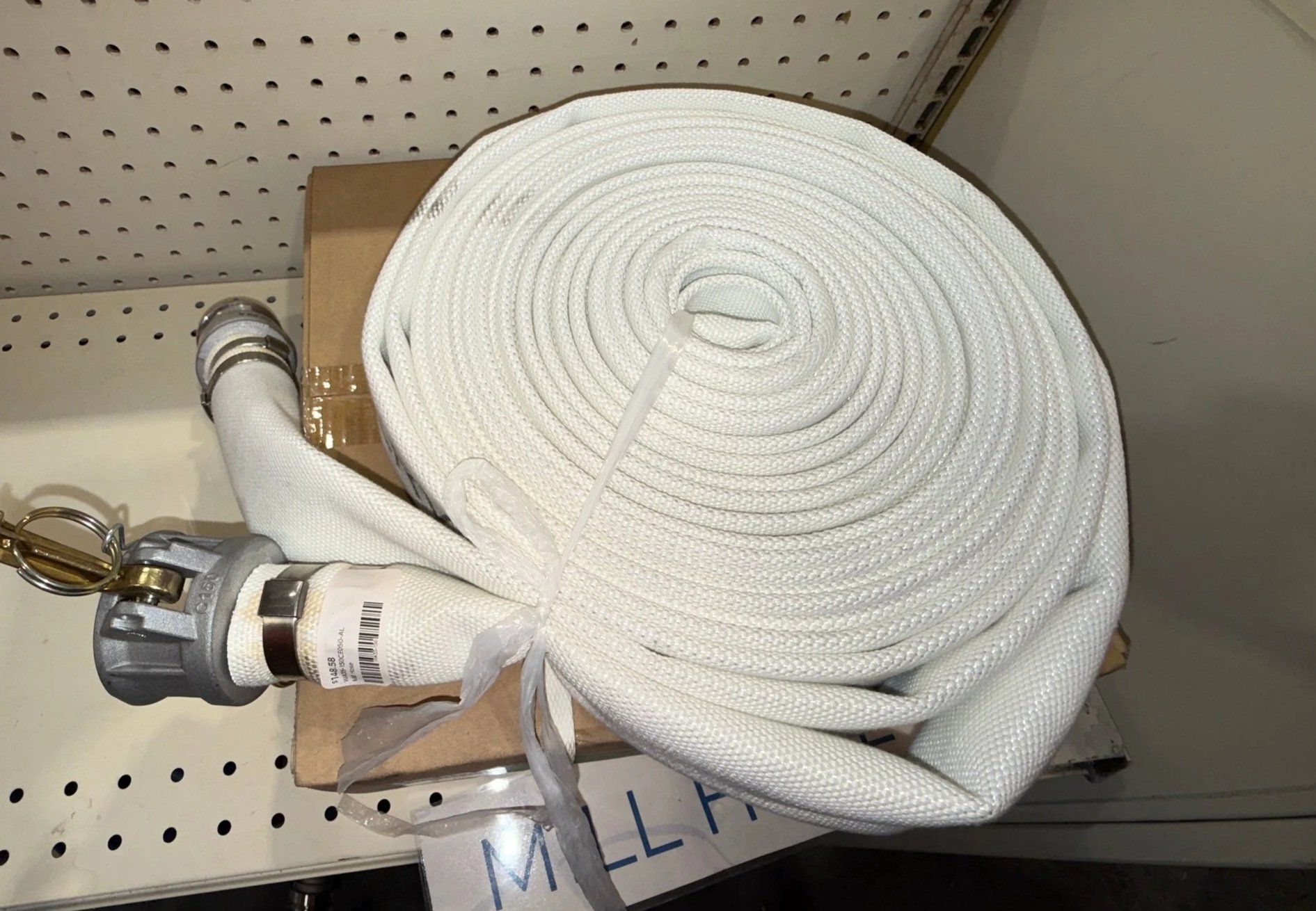 A rolled white fire hose with metal fittings on both ends, hydraulic product for sale in Chester, WV, Pittsburgh tri-state area hydraulics shop and supplies