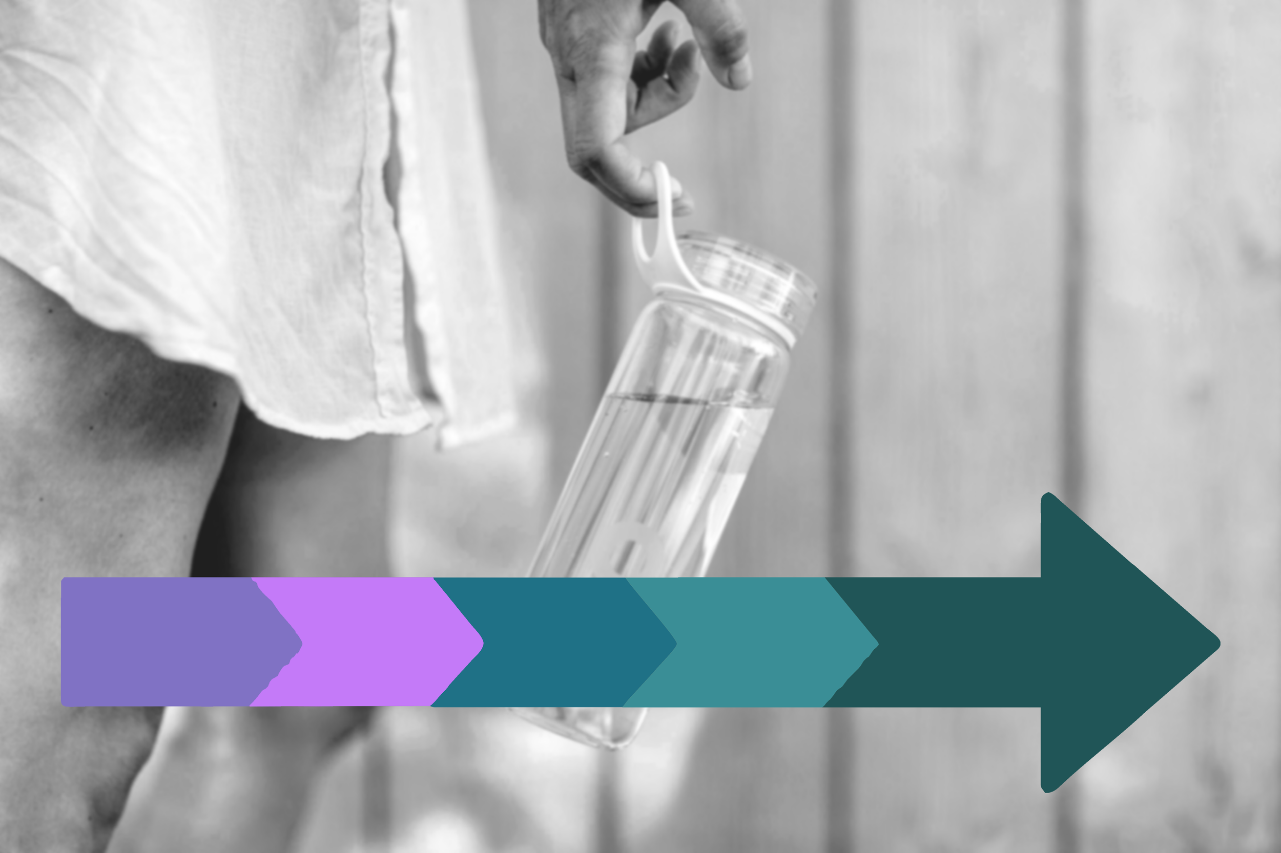 Black and white photo of a person holding a clear water bottle with liquid inside.