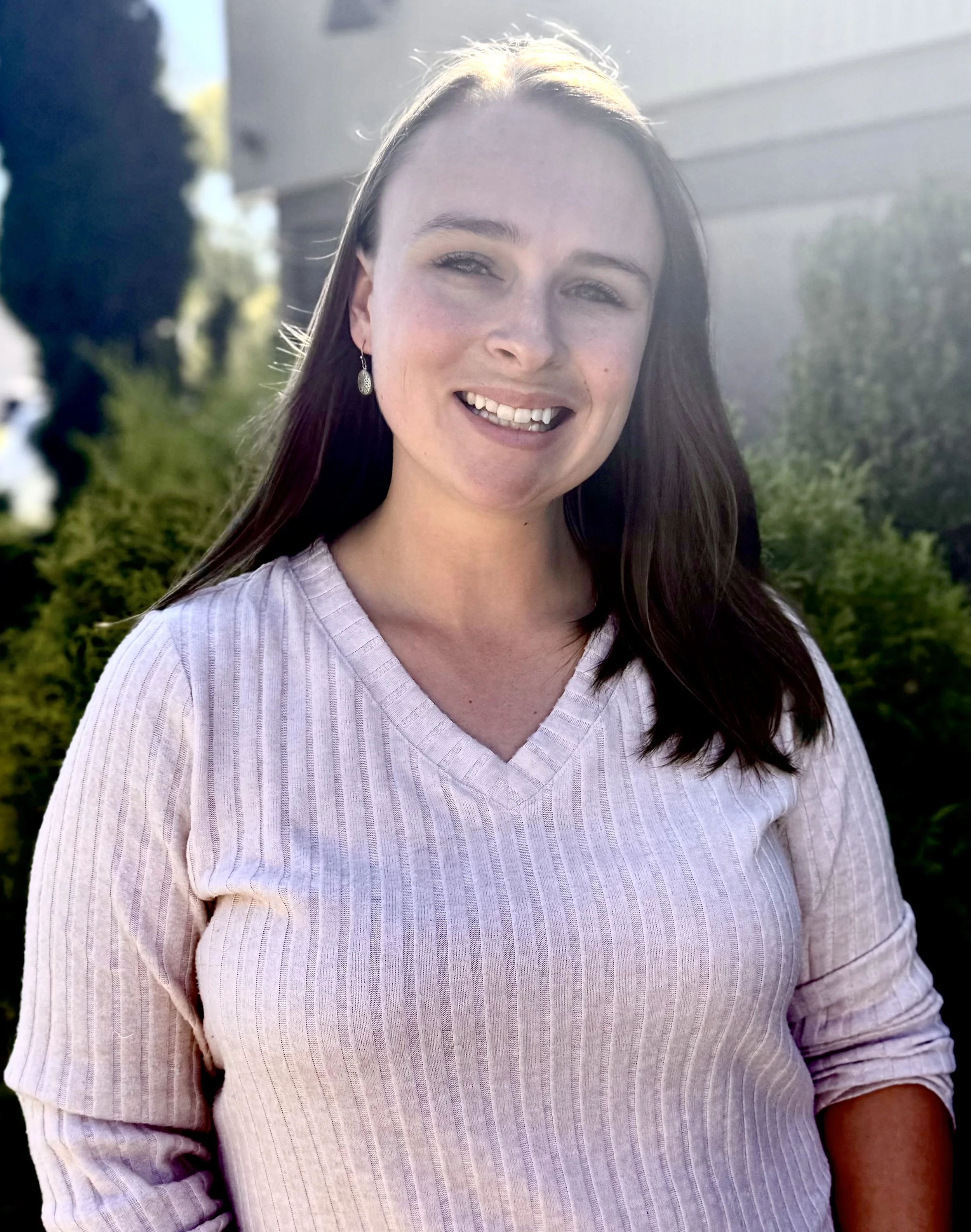 Mychaela Pritchard in a blue shirt smiles for the camera.