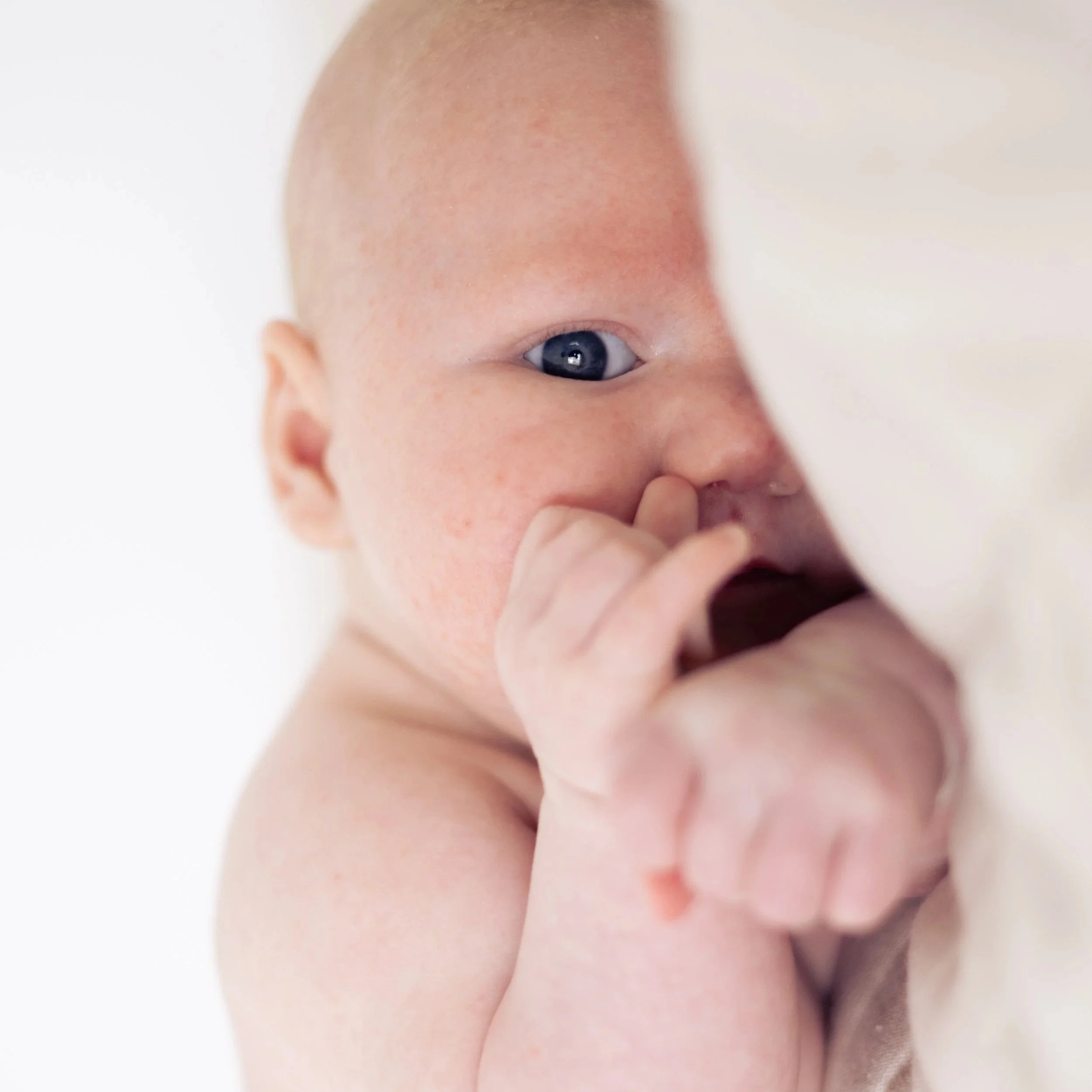 Close-up image of a baby's face focusing on one eye and part of the forehead and cheek.