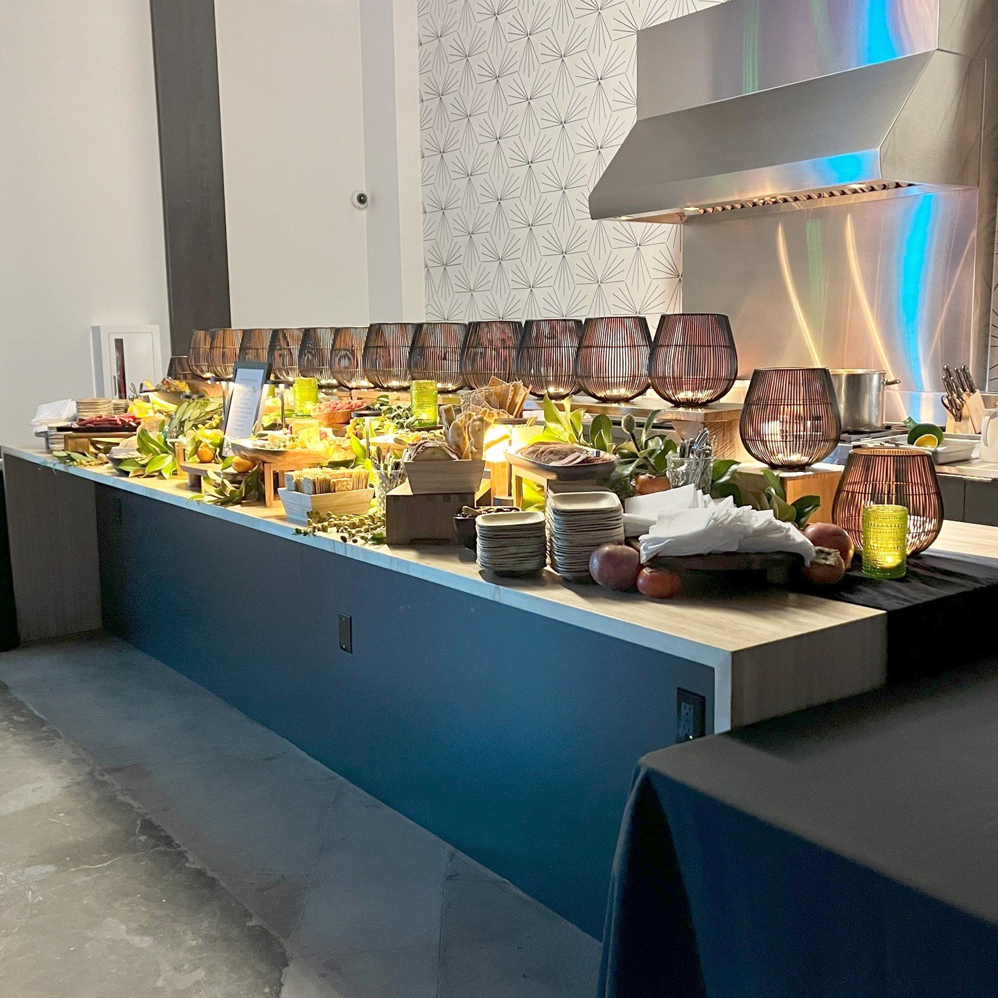 At Stone Way Auto impress your guests with a delicious buffet or artfully arranged charcuterie board, served on a sleek custom wide butcher block counter with ample space for guests to move around comfortably. Lighting in the modern kitchen space is 
