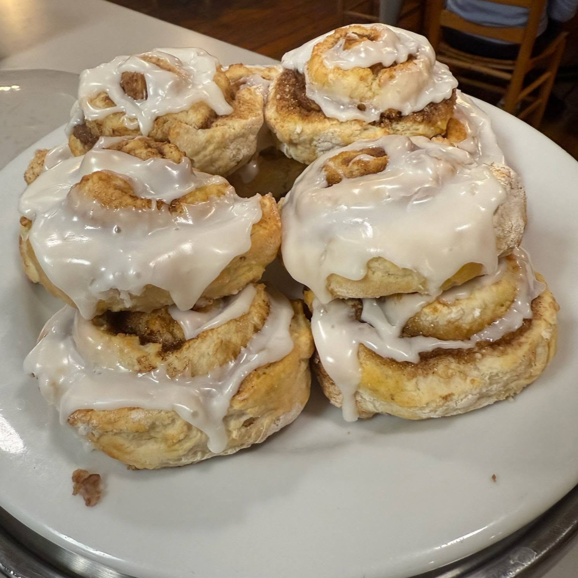 A plate of cinnamon roll with icing on top.