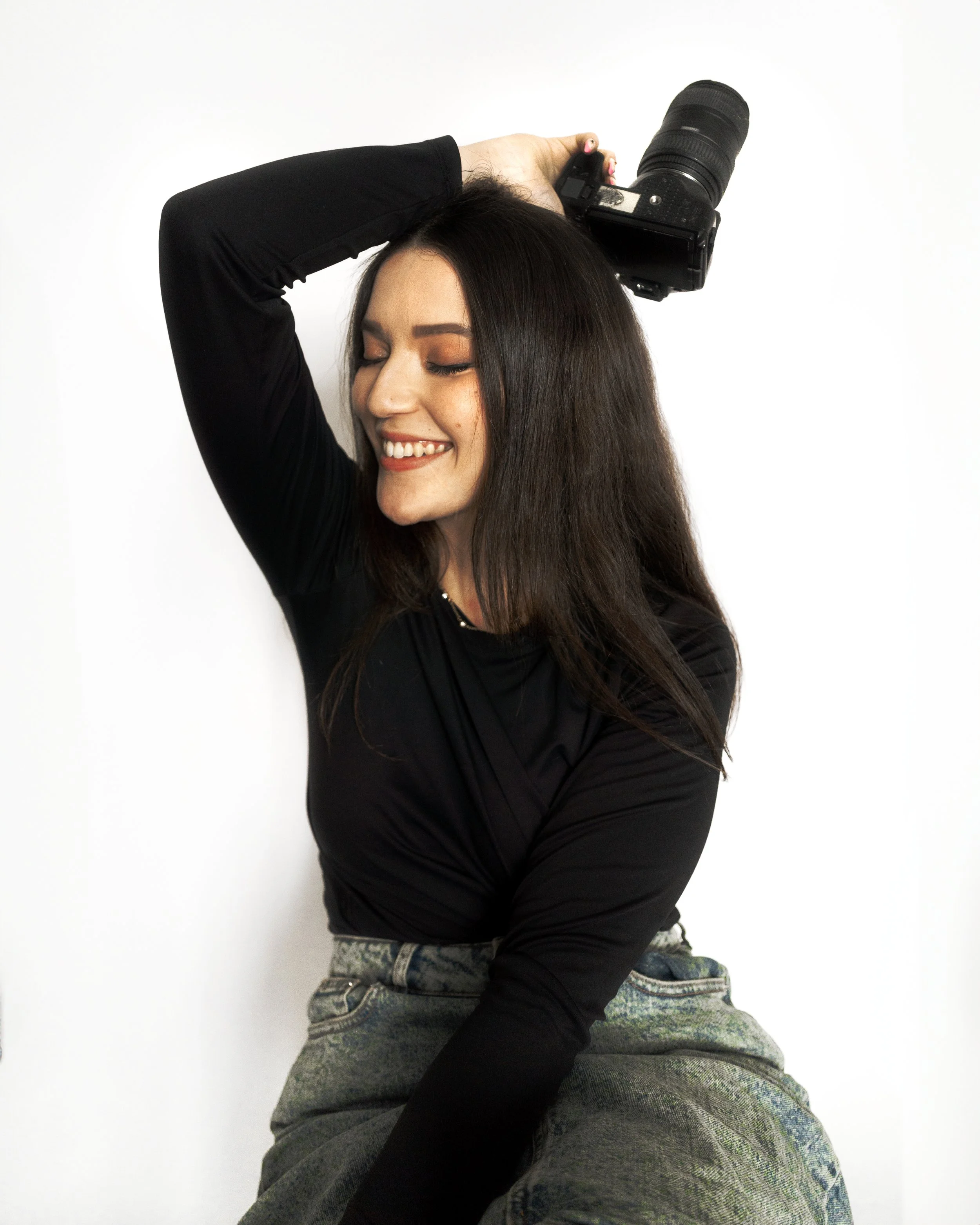 Femme souriante tenant un appareil photo.