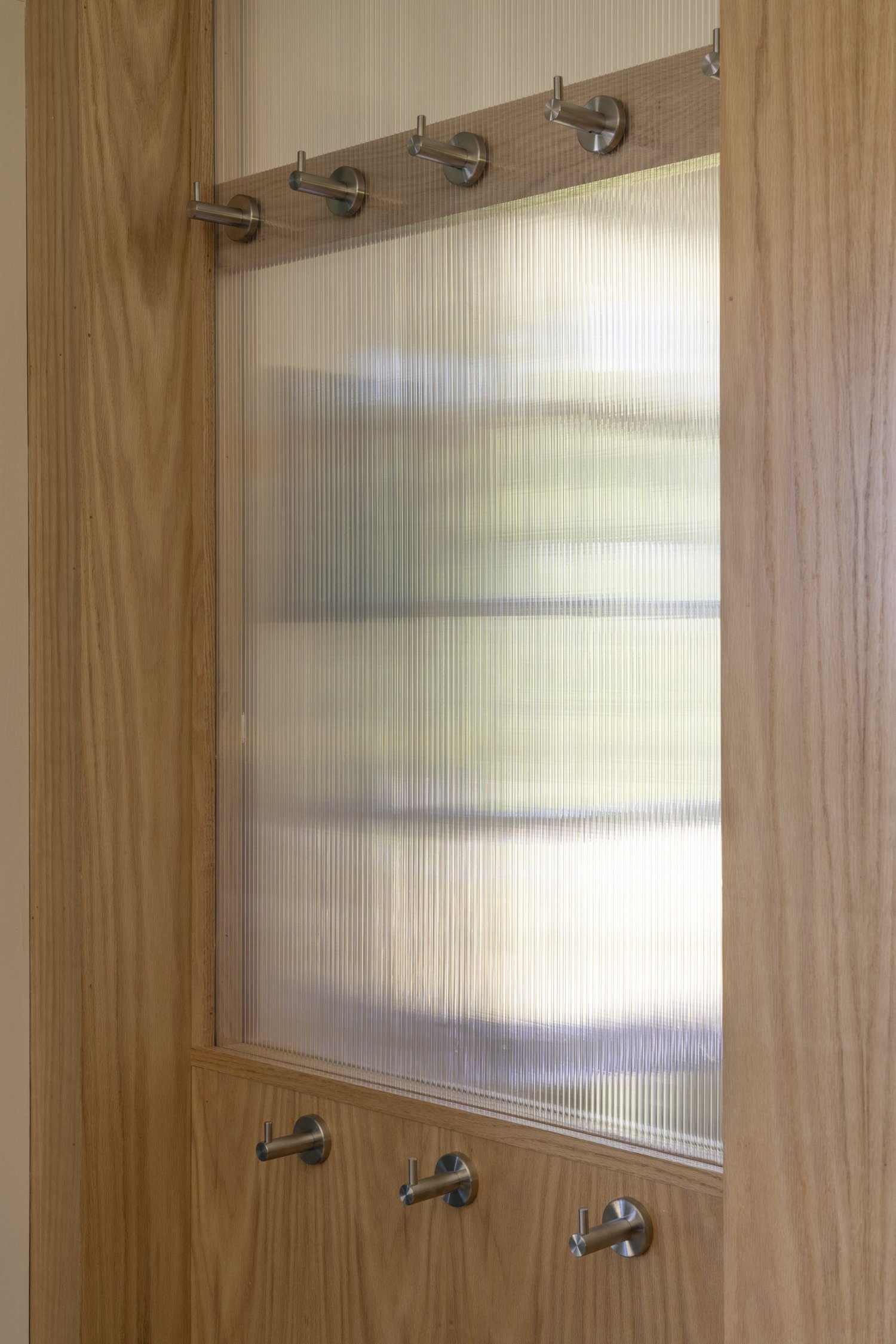 Drumlin House, coat hooks and reeded glass at the entry screen
